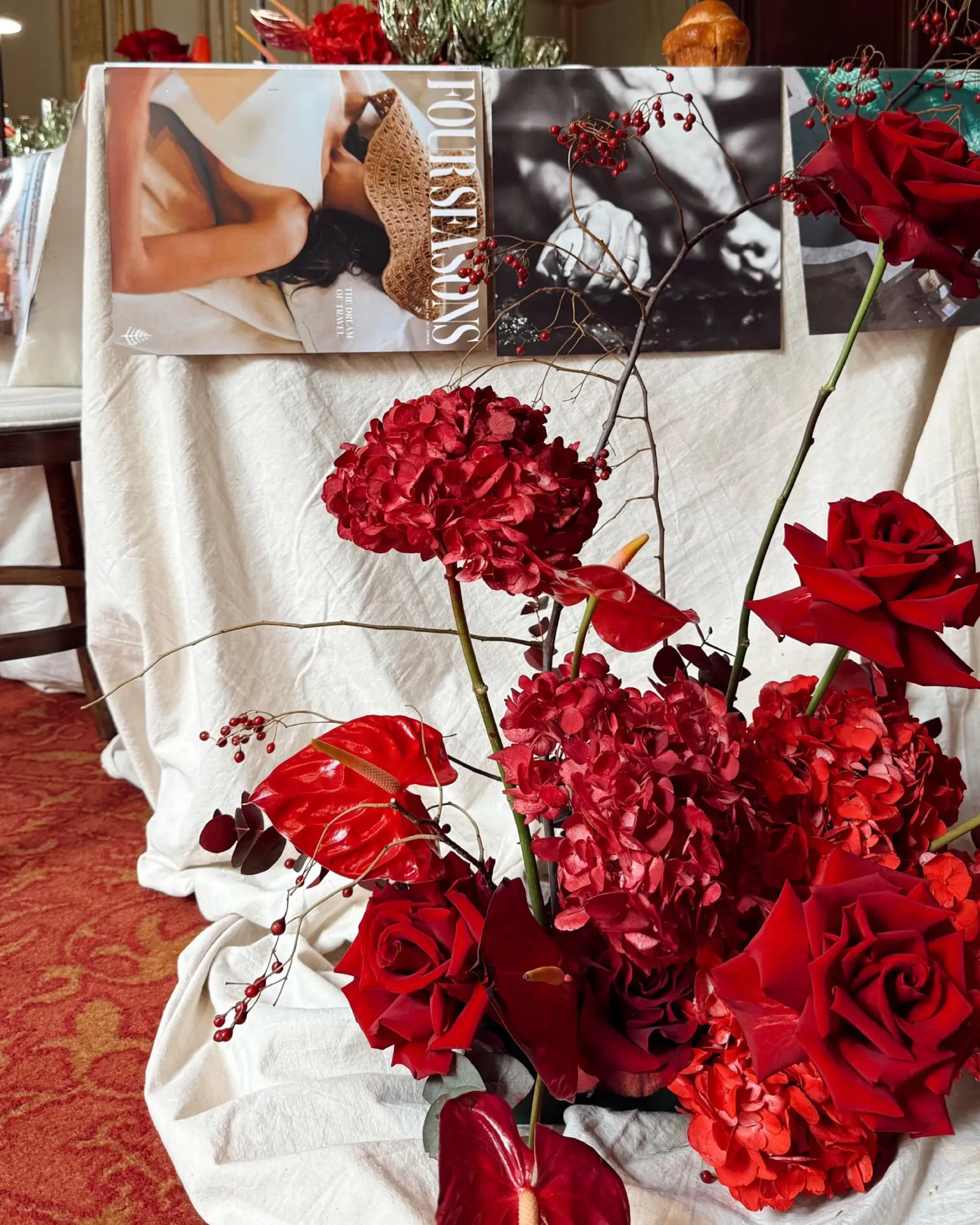 Arreglo de rosas rojas y anturios frente a revistas Four Seasons.