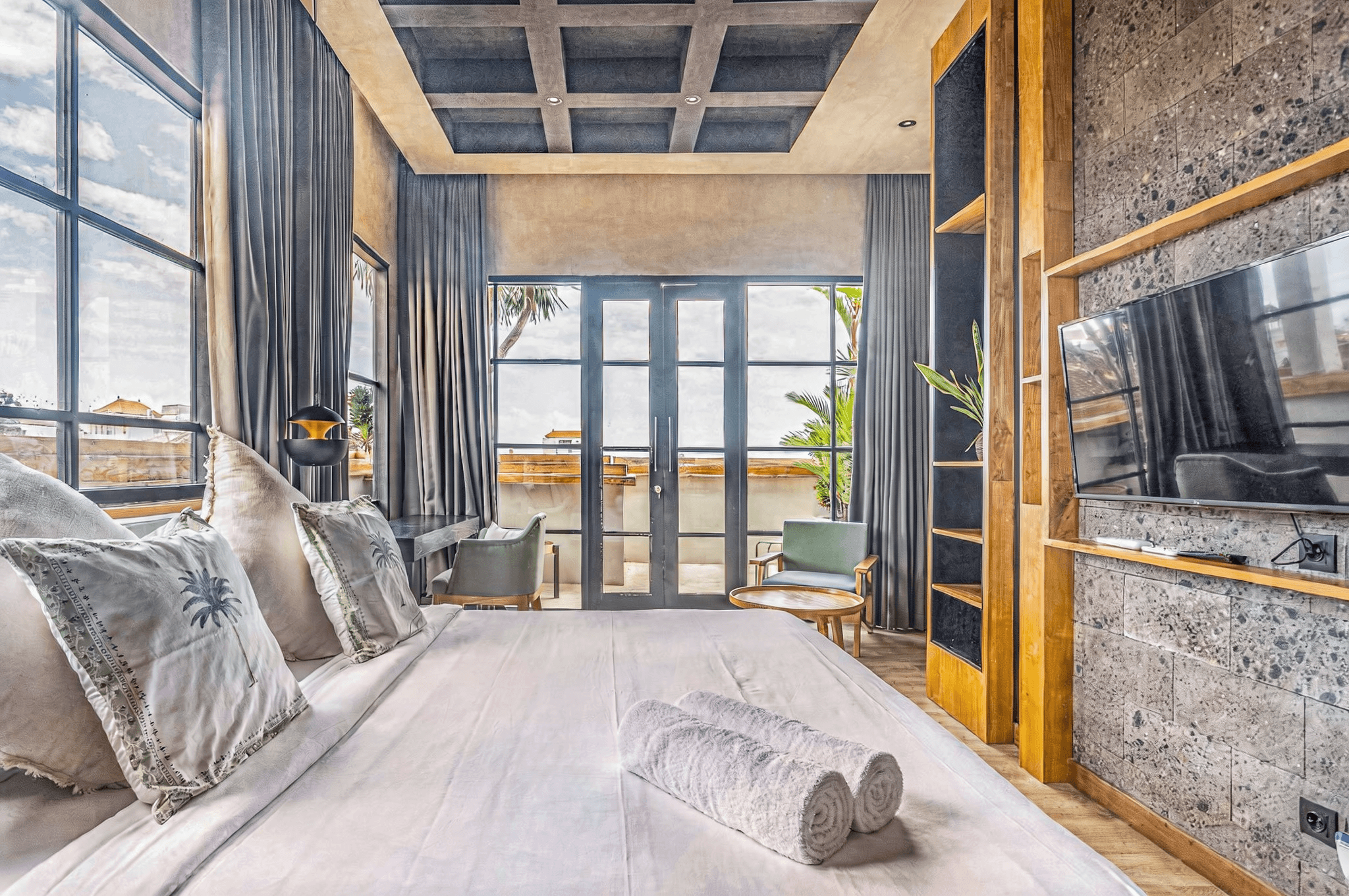 Luxury bedroom with industrial accents and balcony access. Premier real estate agent services in Canggu, Bali.