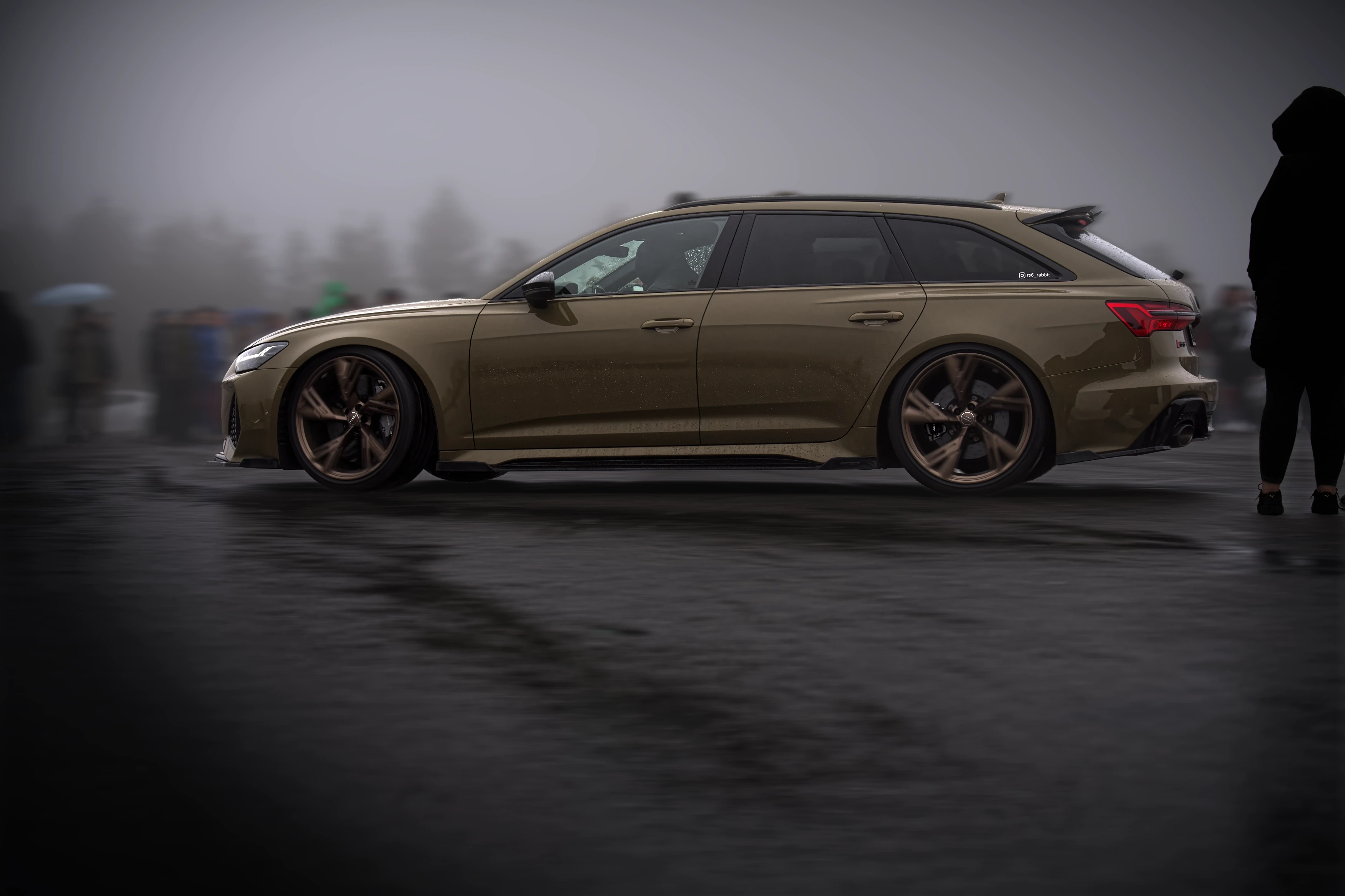 Sandfarbener Audi RS6 Avant beim Audi RS Treffen Crottendorf 2025, inszeniert im Nebel auf nasser Asphaltfläche.