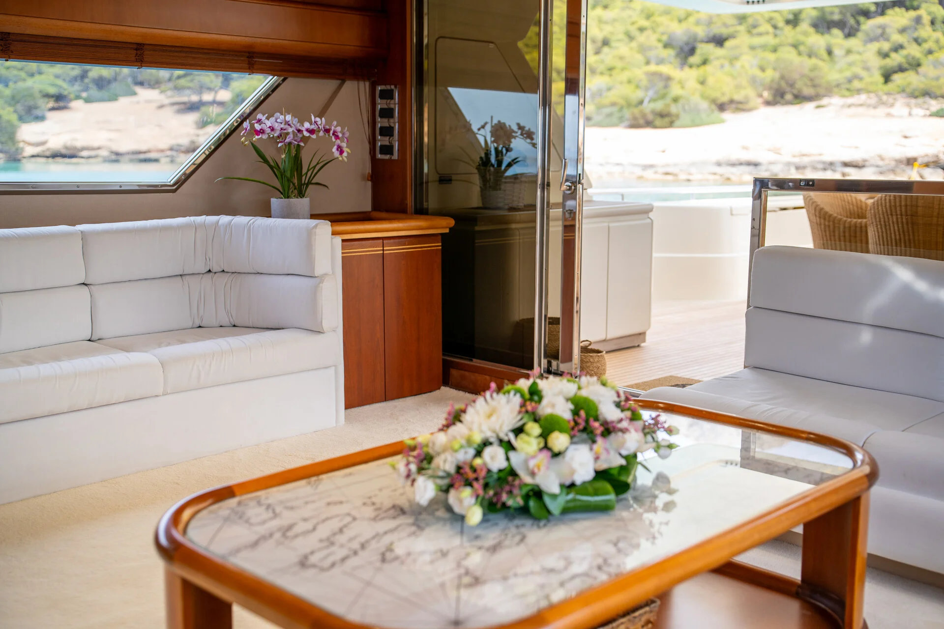 White Rock 36 speedboat with captain at helm cruising calm blue waters near Paros coastline with hills in background.