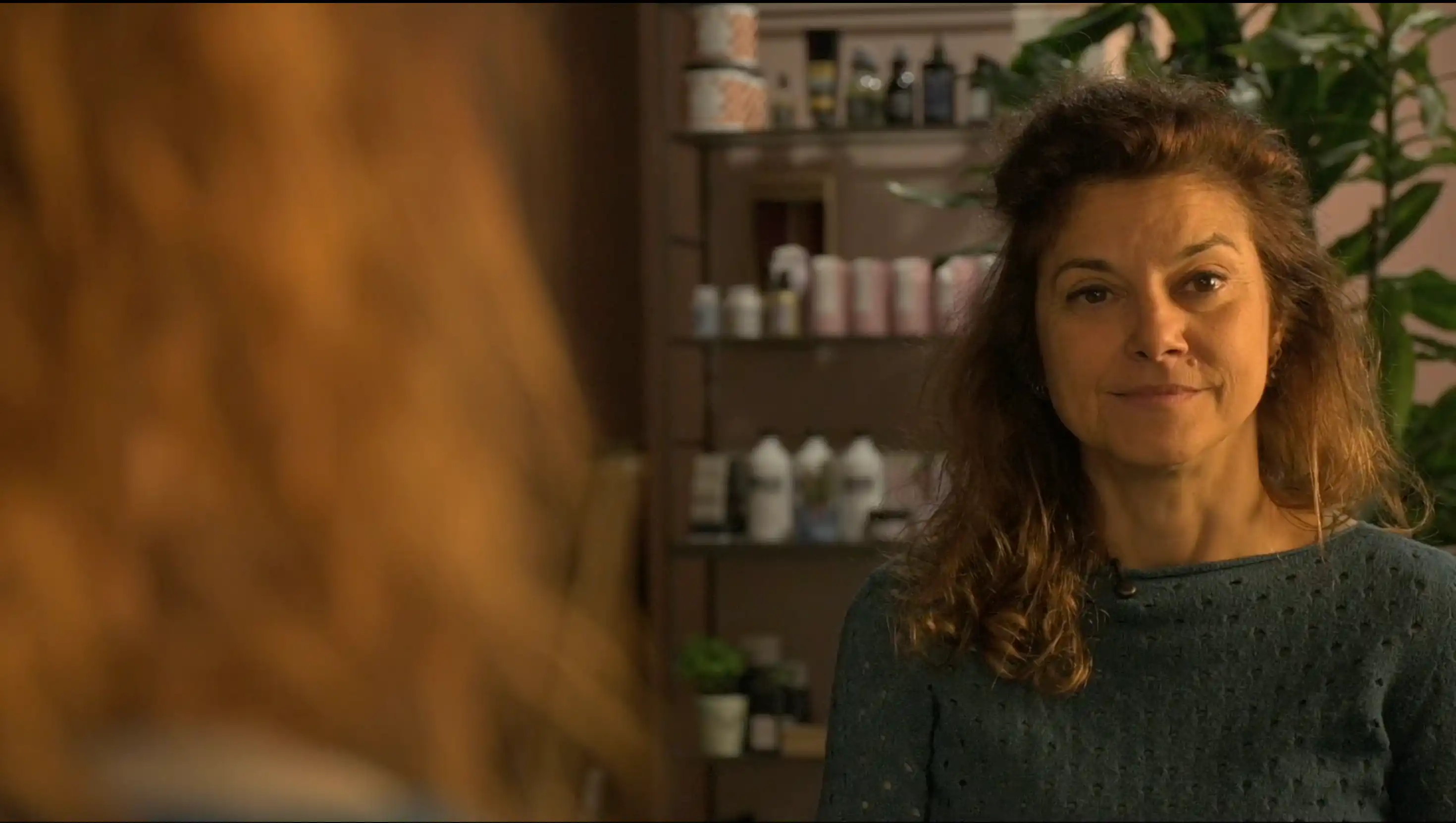 Donna seduta davanti ad uno specchio nel salone di parrucchieri Repubblica delle Donne di Forlì durante le interviste per il docufilm Donne in Bilico