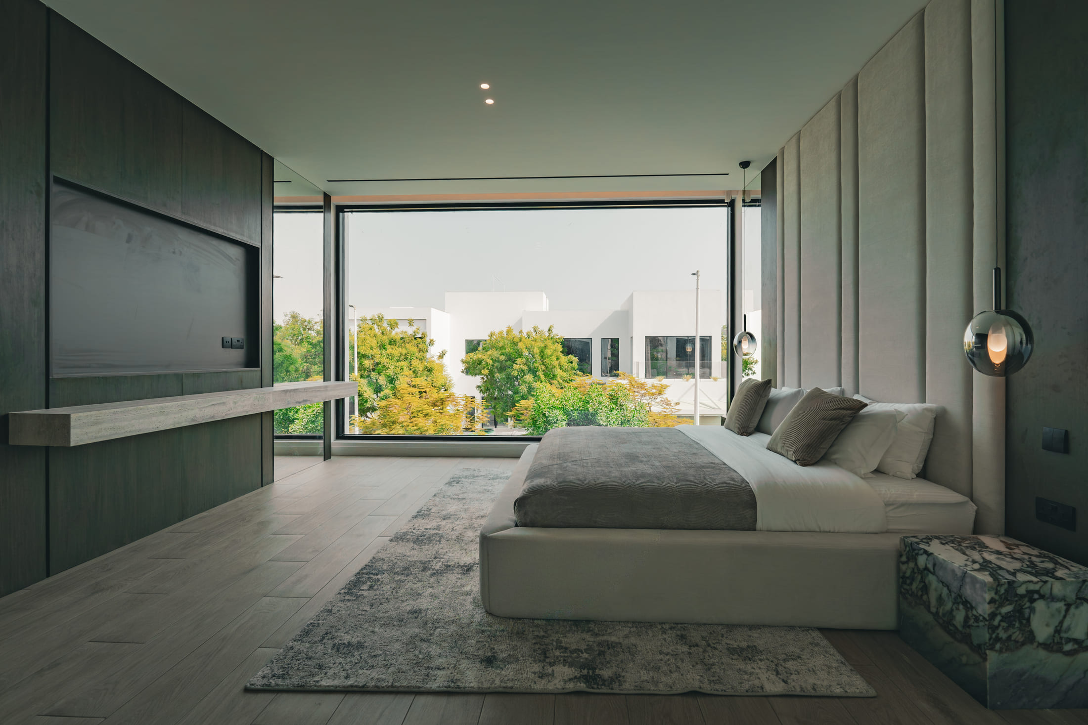 Image of a large villa with big glass windows & a pool 