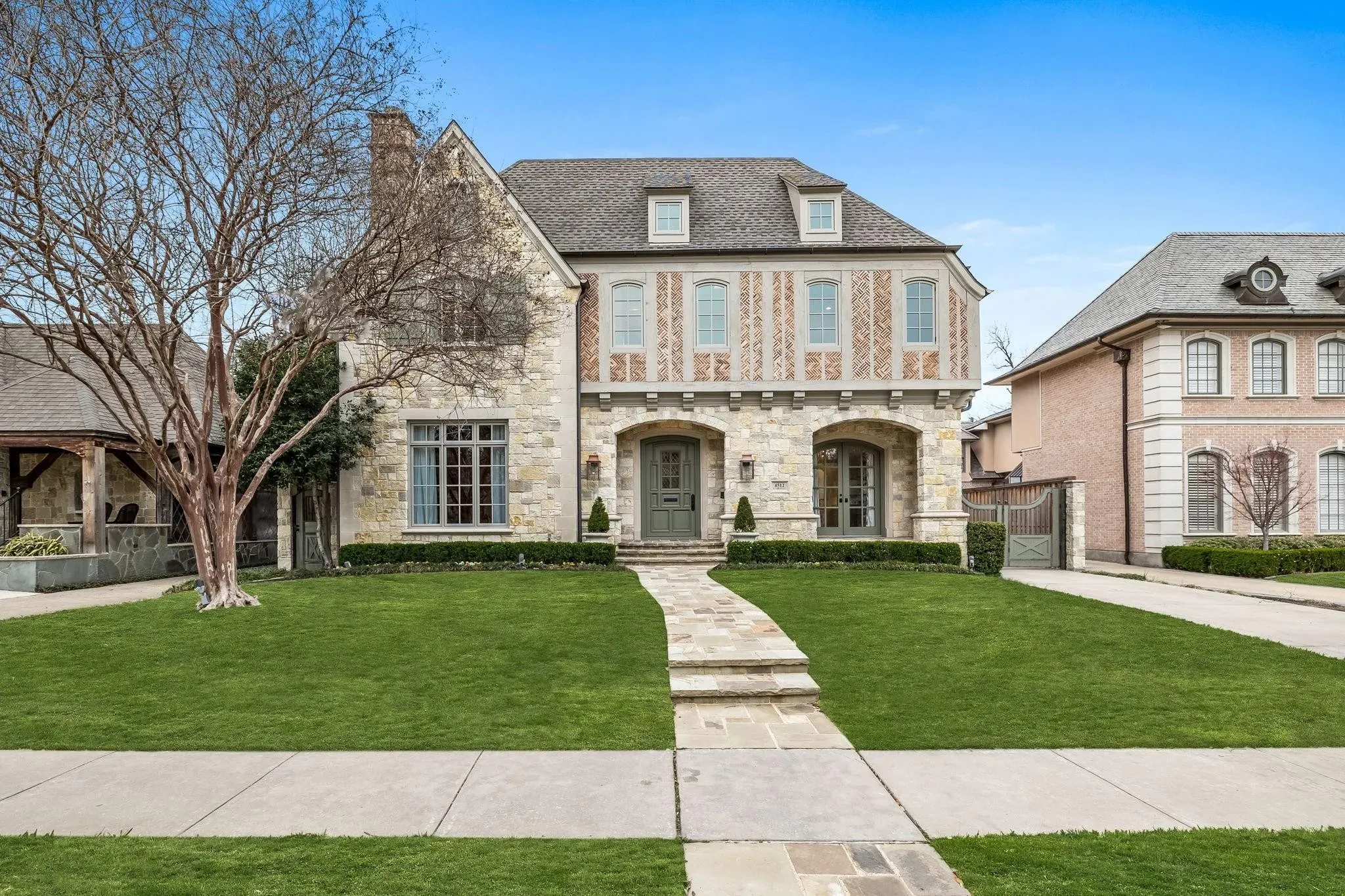 Highland Park Texas home with new GAF Timberline HDZ shingles in Weathered Wood color, showing Tudor-style architecture with stone and timber details