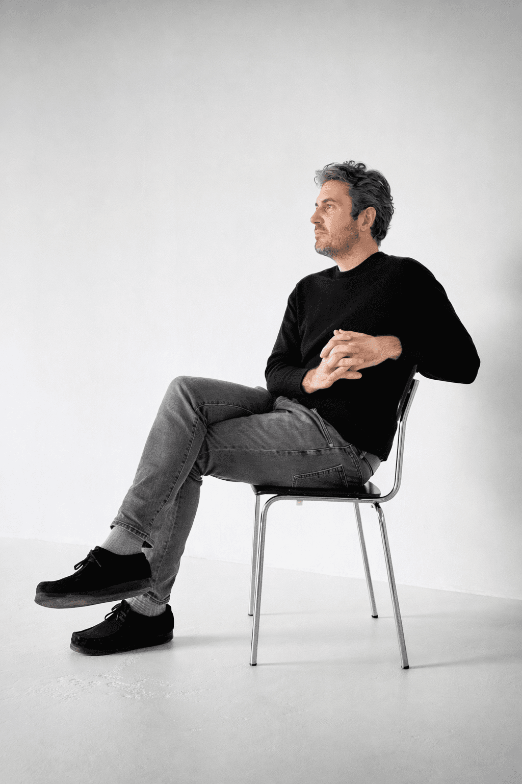 ir. Koen Verhees, architect, bespoke design studio, rotterdam, architect zwart trui zit op een stoel in moderne studio