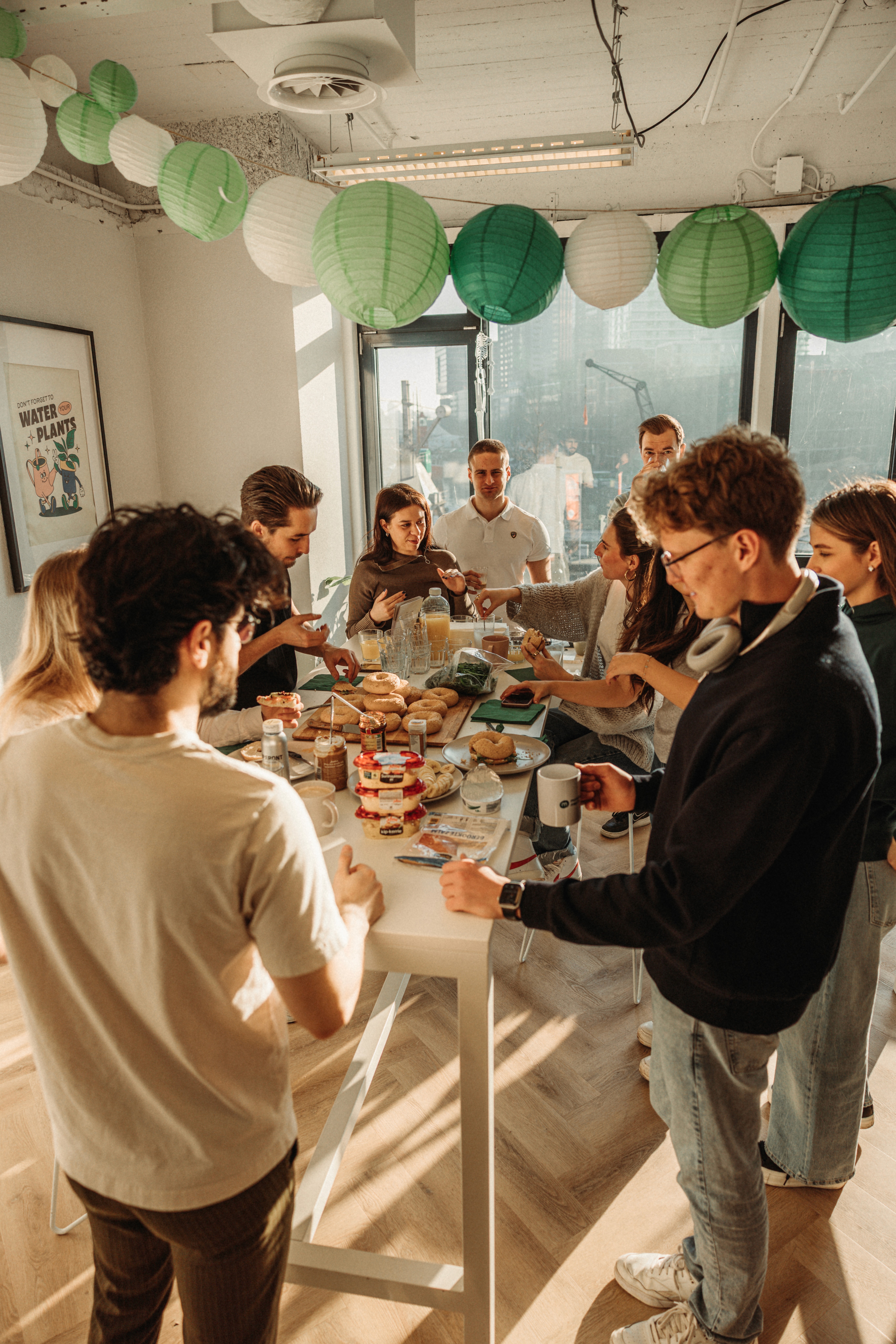 A person in an office smiles while talking on the phone, surrounded by paperwork and office supplies.