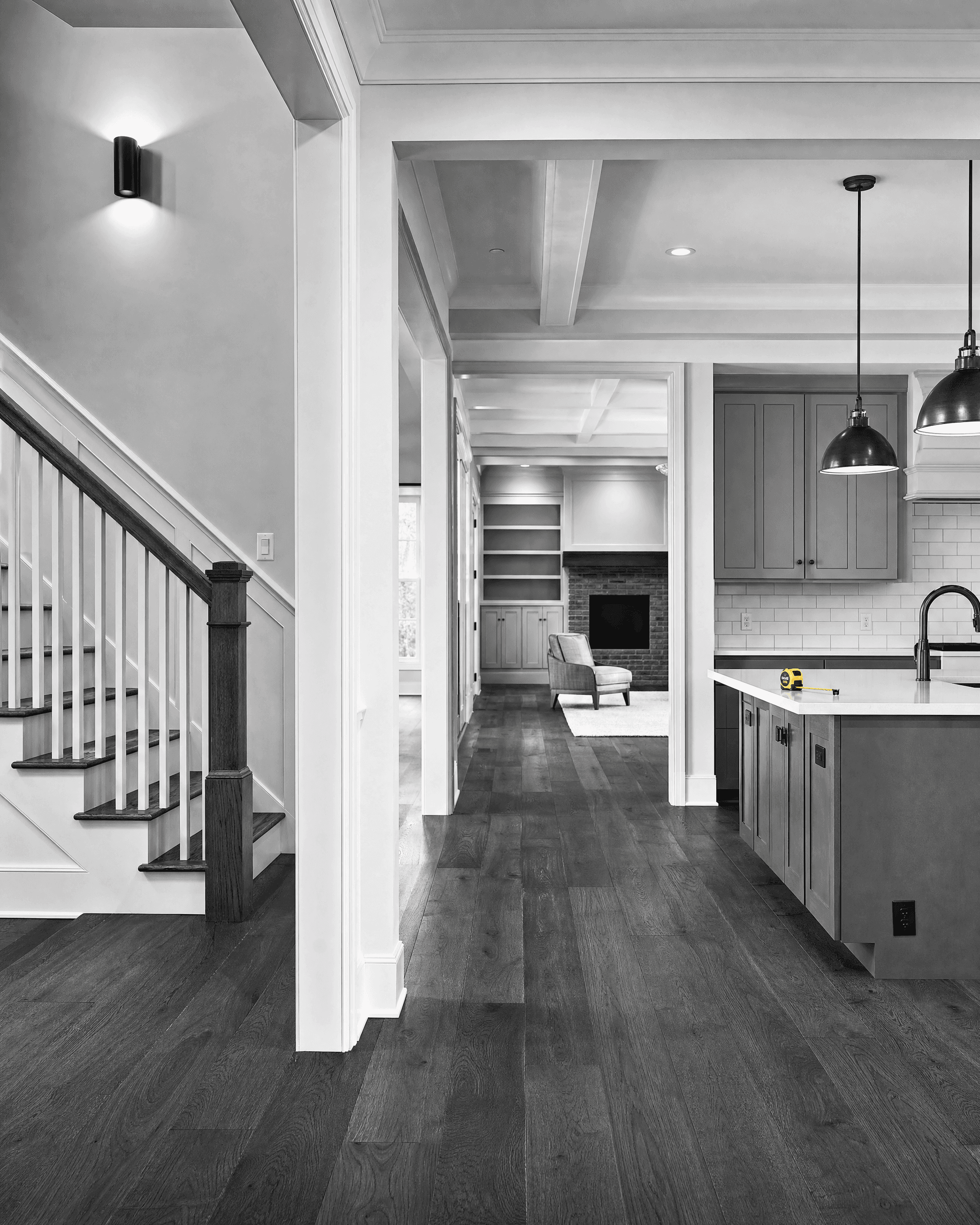 Completed residential renovation with integrated staircase, kitchen, built-ins, and connected living spaces.