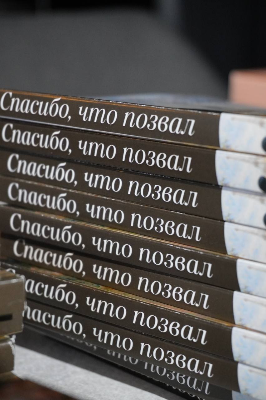 A couple stands outdoors at sunset.