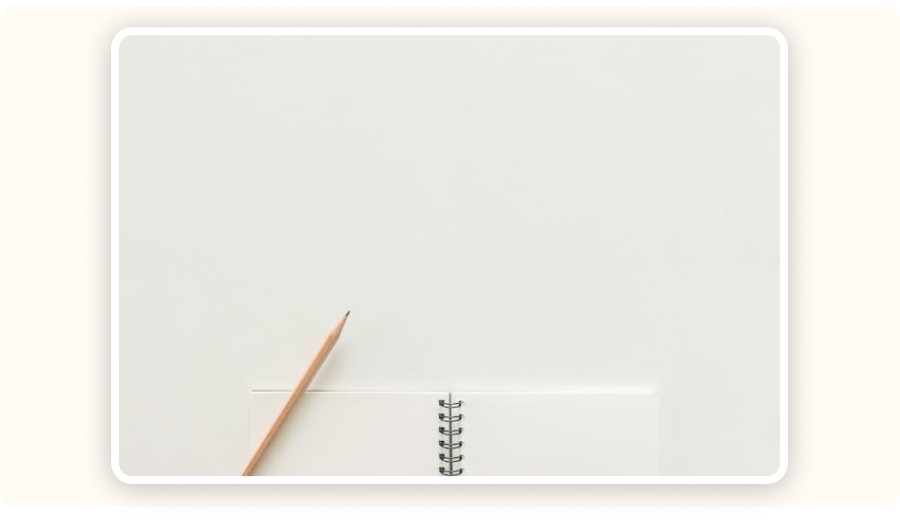 Carnet de notes ouvert et crayon sur fond neutre, symbole de prise de notes et d'apprentissage structuré