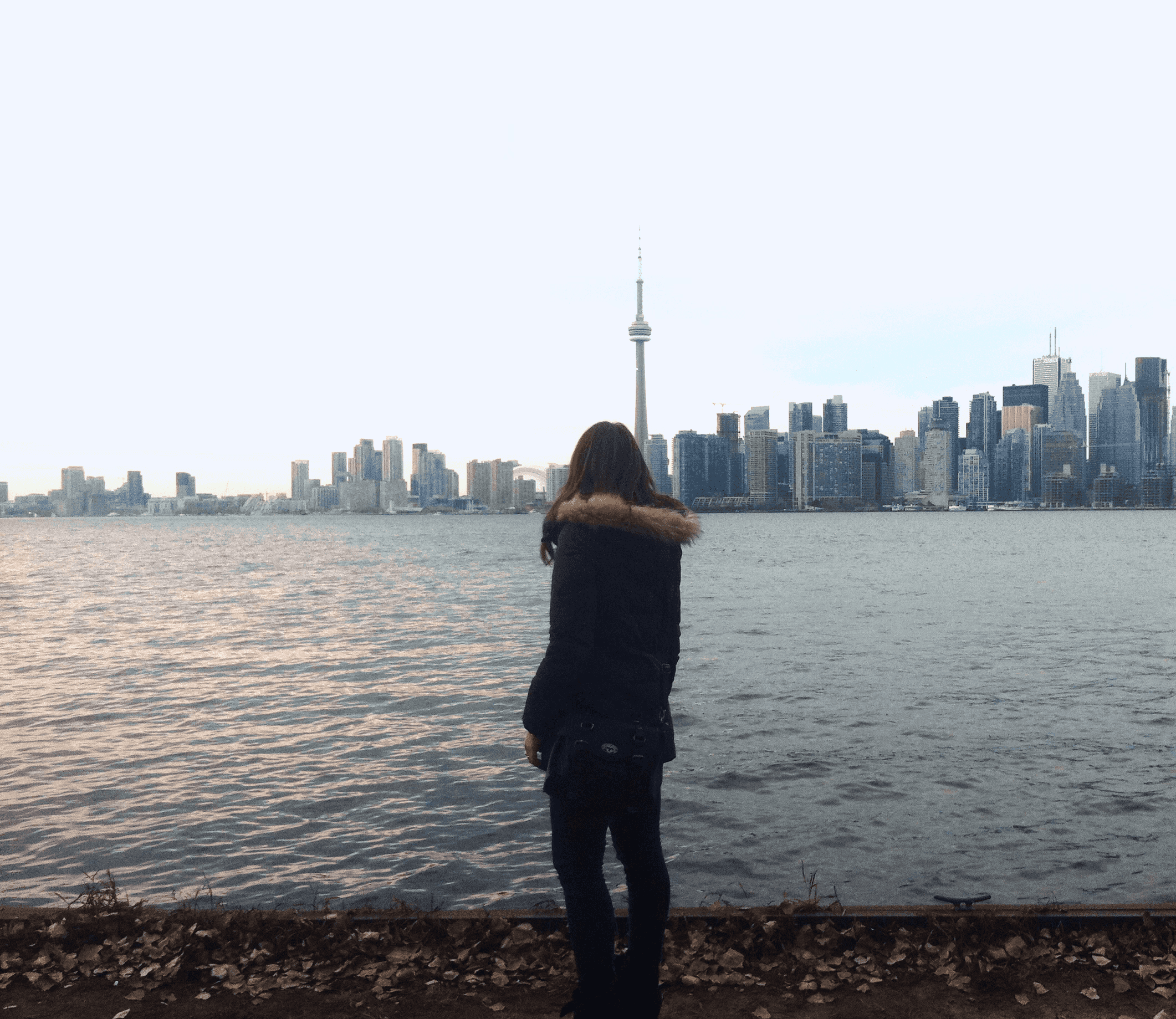 a-woman-looking-at-CNTower-Toronto-bay-skyline