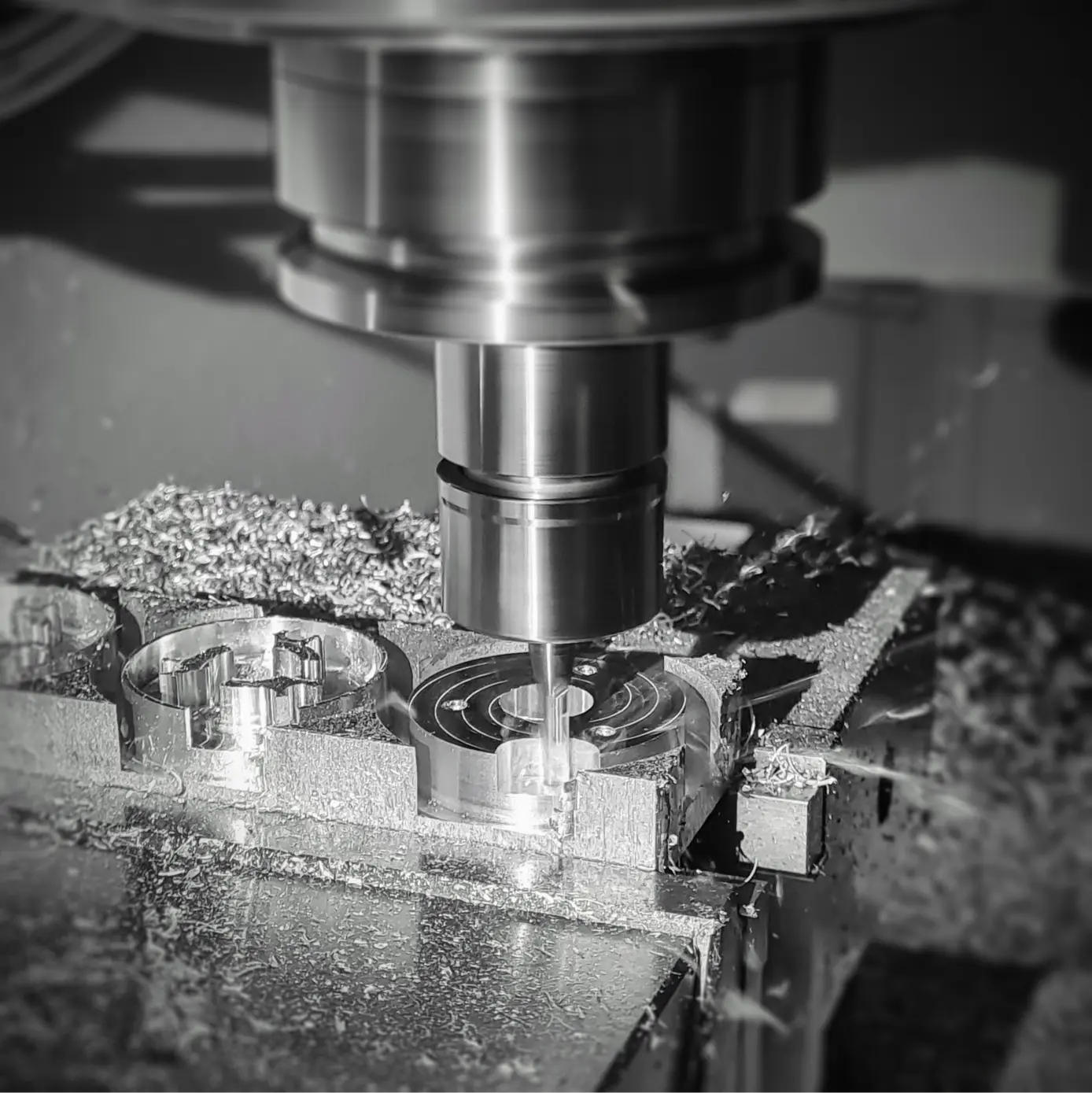 Black and white image of people working at a table with laptops, showing hands gesturing during discussion of digital content displayed on screens, with fabrica® logo in the corner.