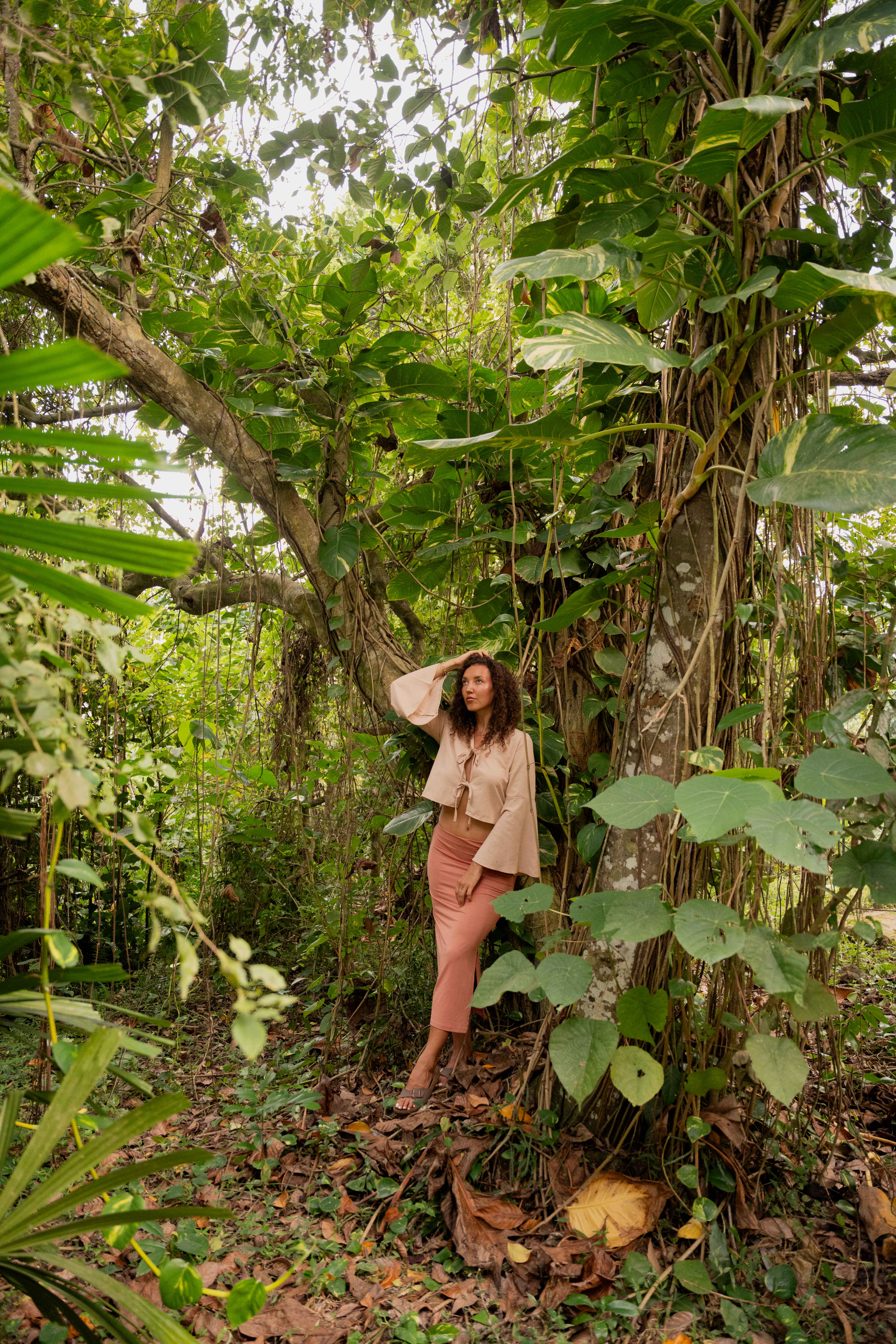 Girl leaning on a tree brushing through her hair
