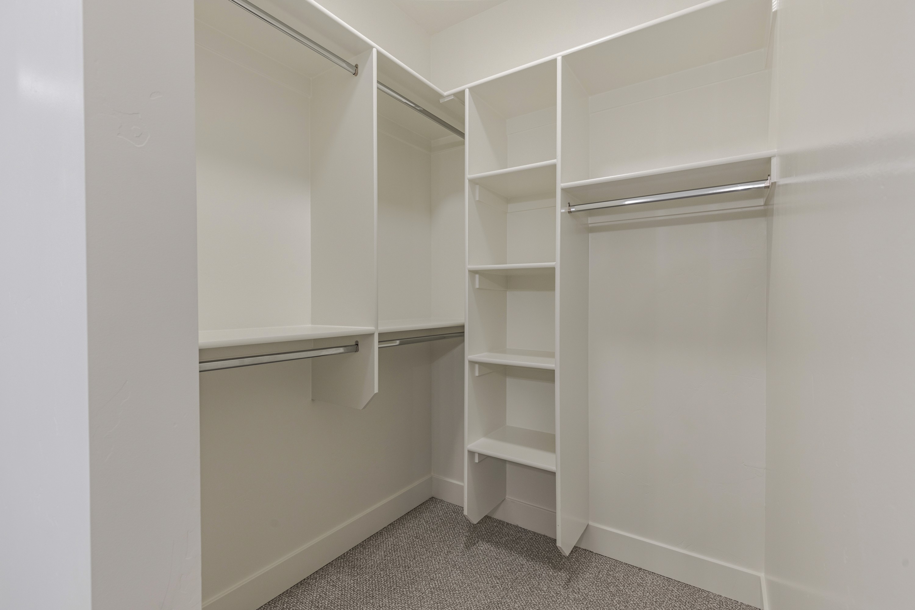 Master closet in the Painted Sands twin home in Hurricane, Utah featuring built-in storage and organized shelving.