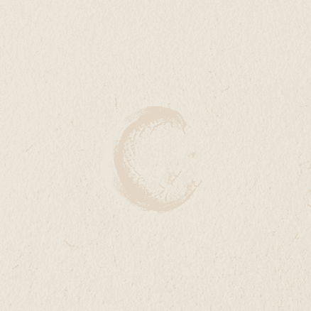 Small smear of balm spread thinly across a smooth neutral surface.