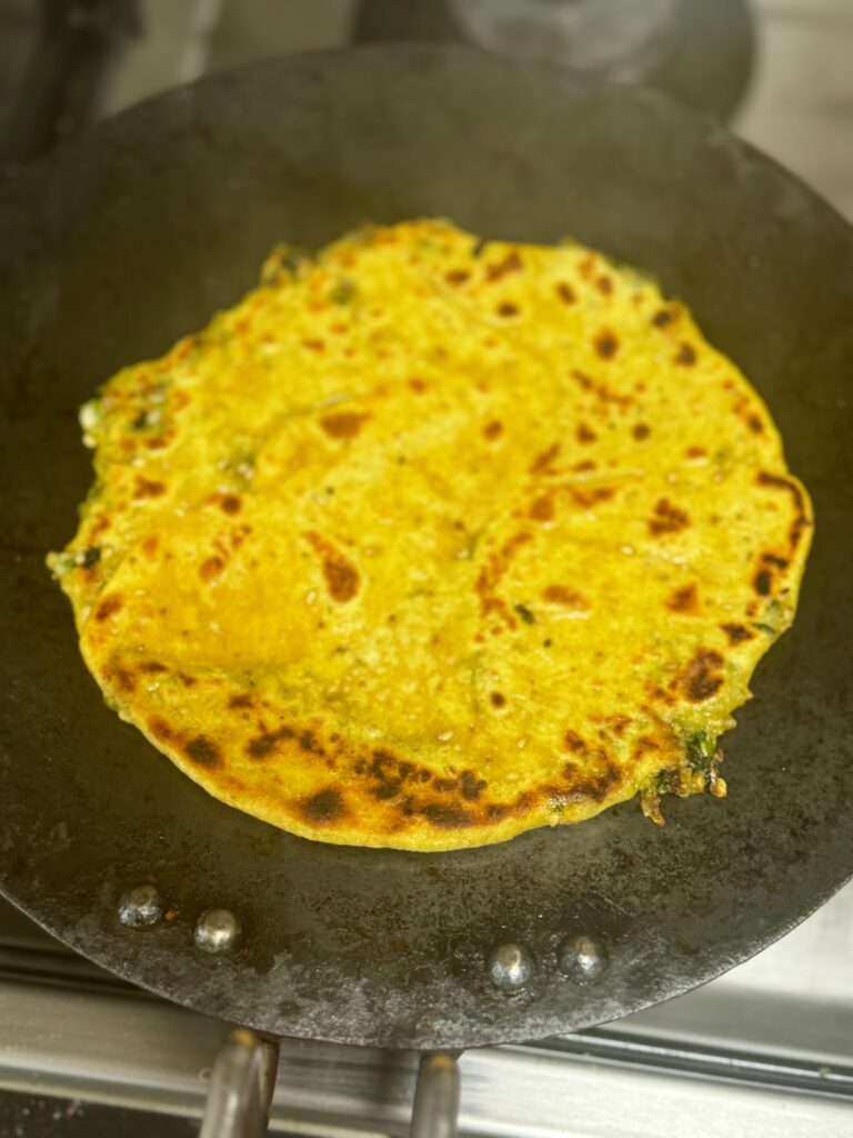 Thecha paratha cooking on the griddle.