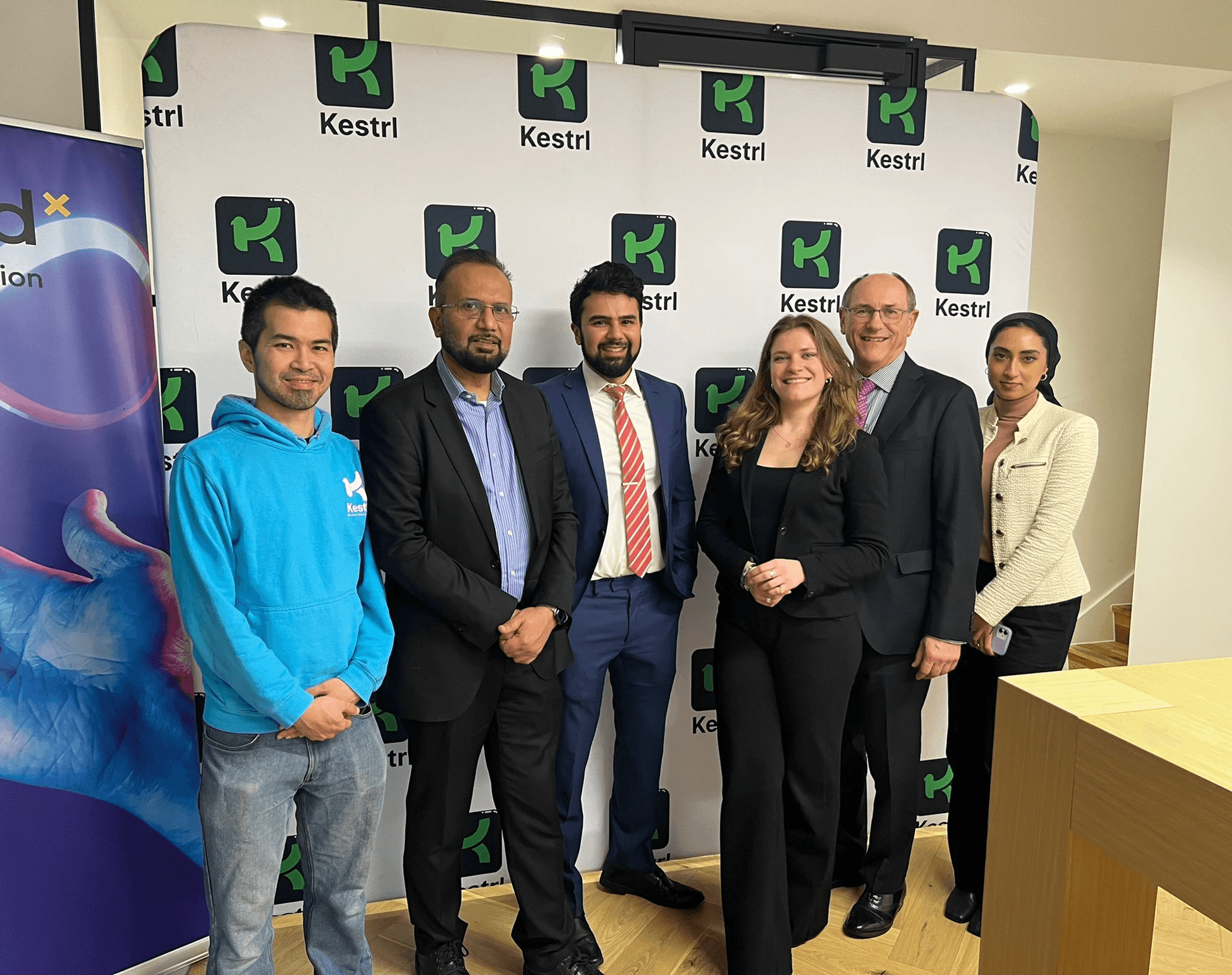 Woman working on a laptop computer at a table in a bright room.