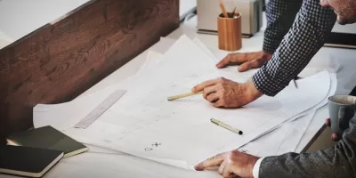 due persone guardano disegni affiancati si confrontano