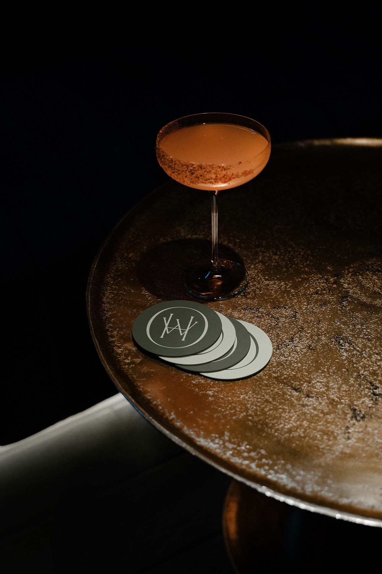 Copo de cocktail sobre mesa com porta-copos da marca Waldheim.