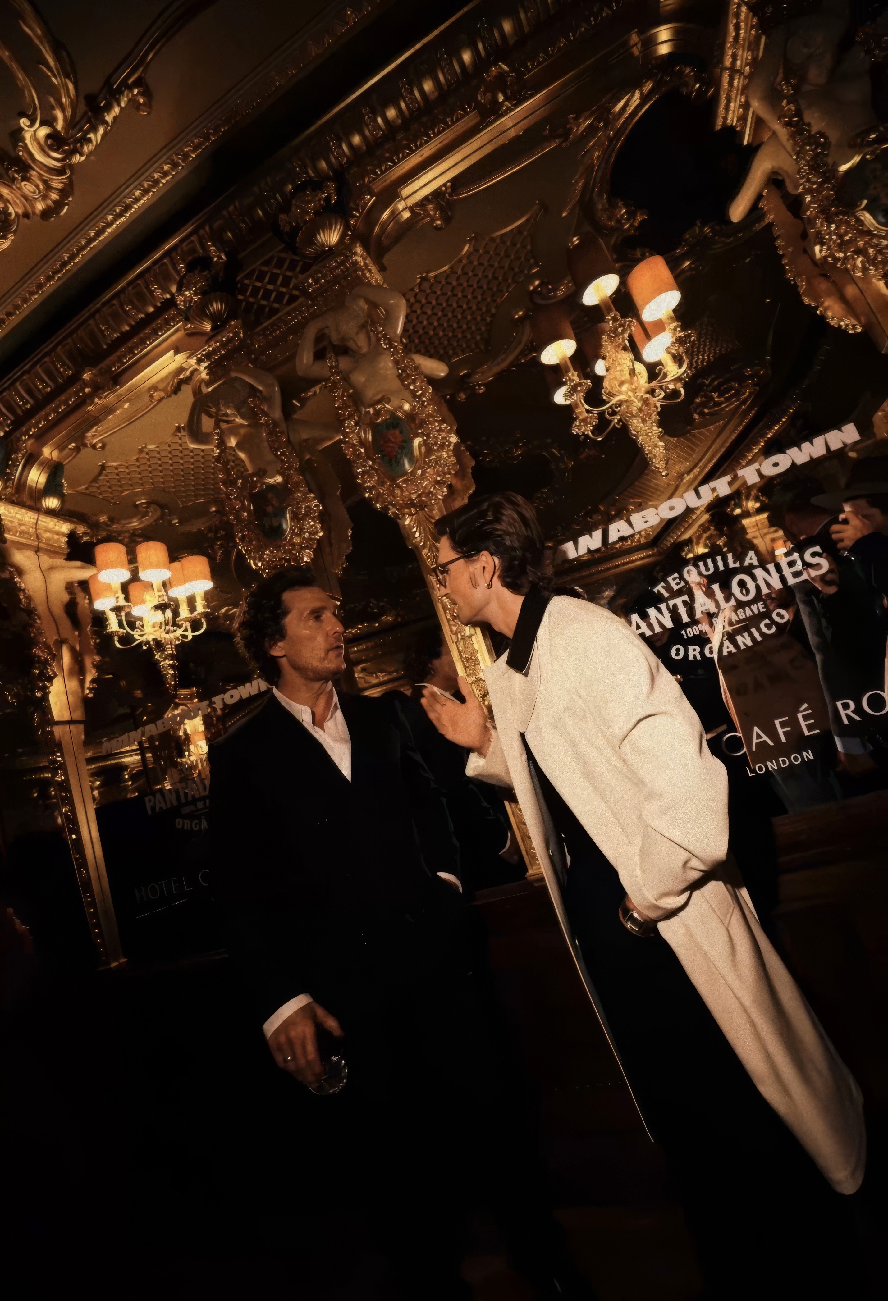 Bride sitting on ground against wall, groom standing nearby