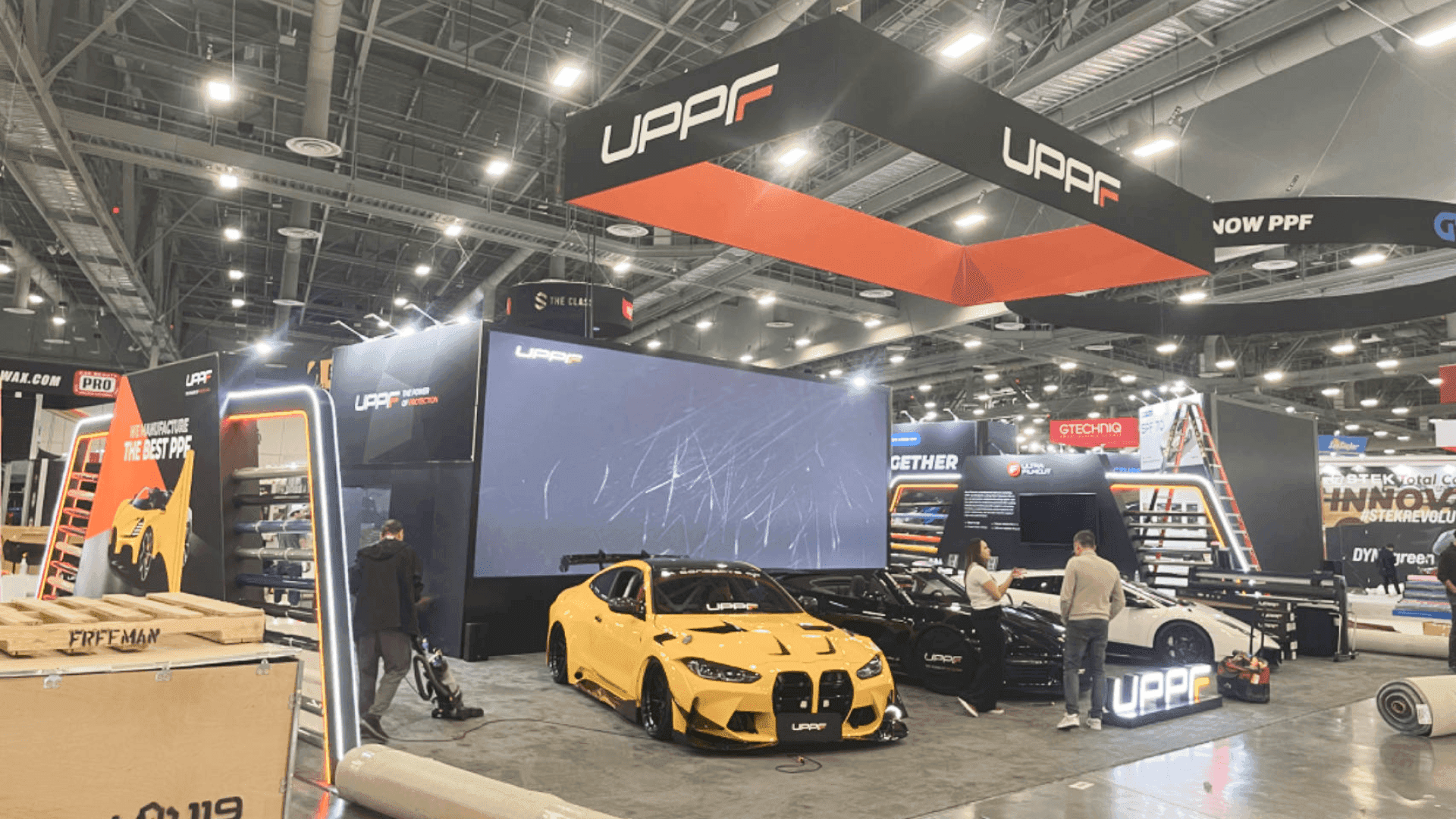 Advanced commercial vehicle display booth at Las Vegas Convention Center arranged with open-entry layout and product kiosk for buyer conversations