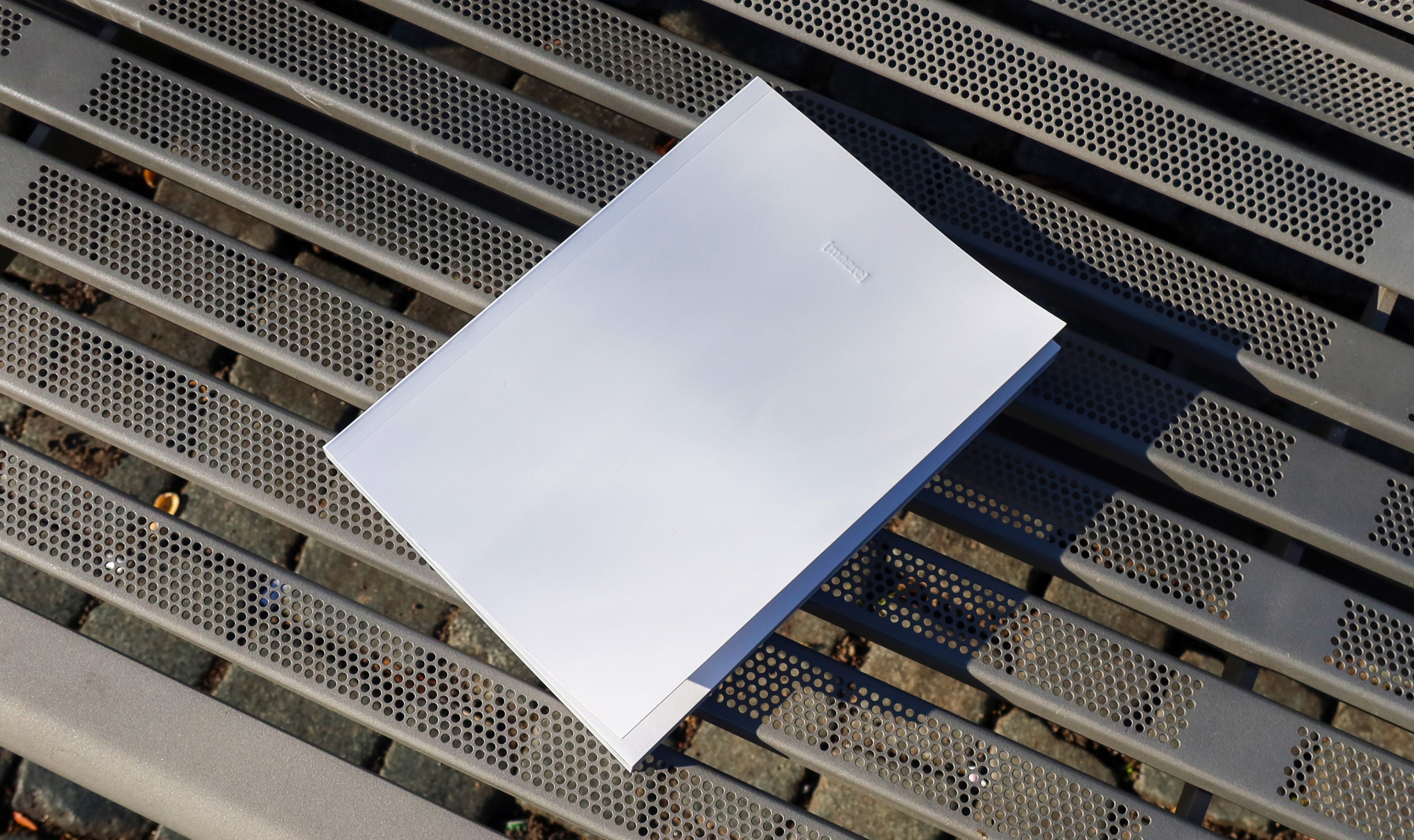 White branded cap with turquoise logo placed on fresh lemons in a red bowl