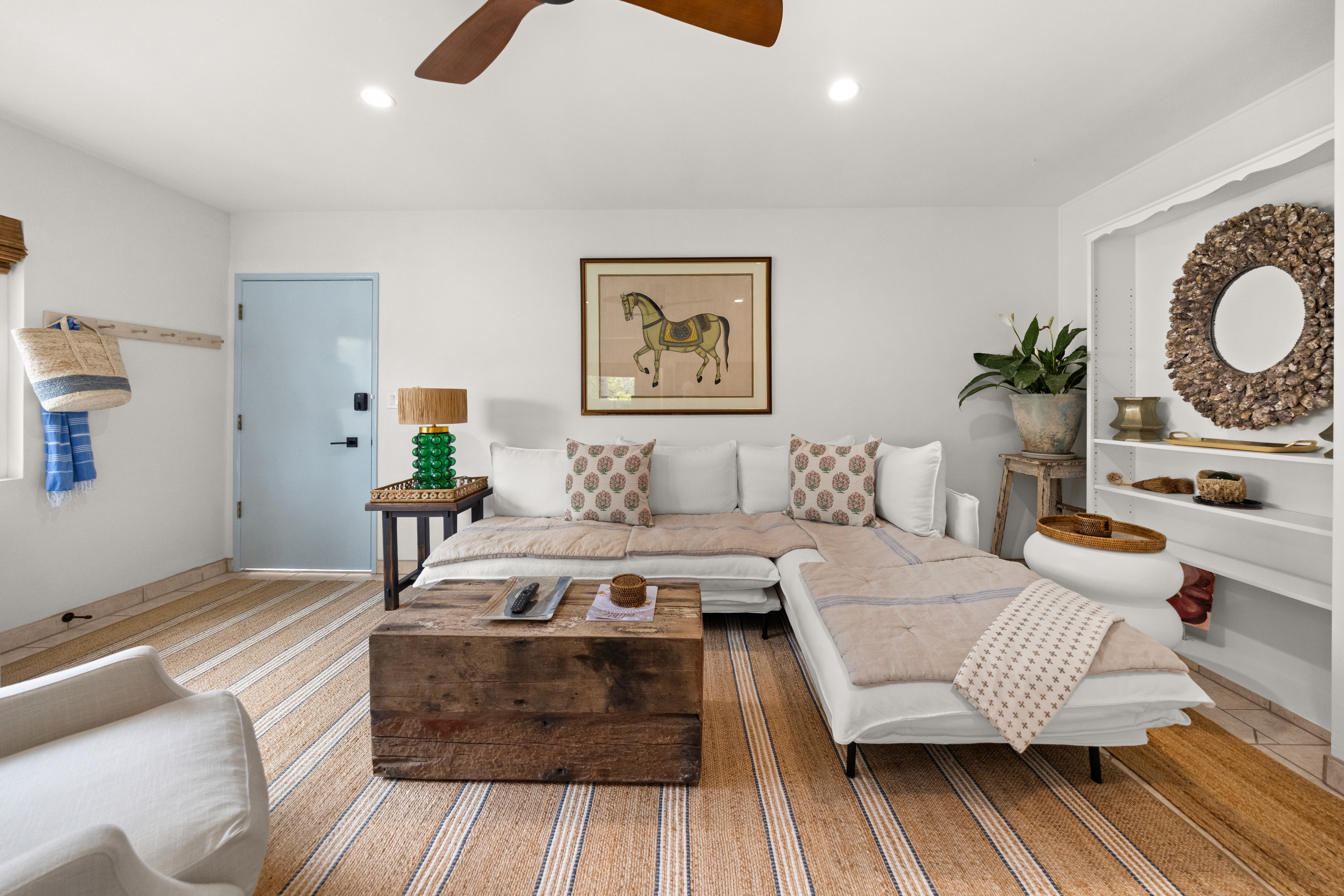 Relaxed, coastal-inspired living room with a deep sectional sofa, curated artwork, and natural textures throughout.