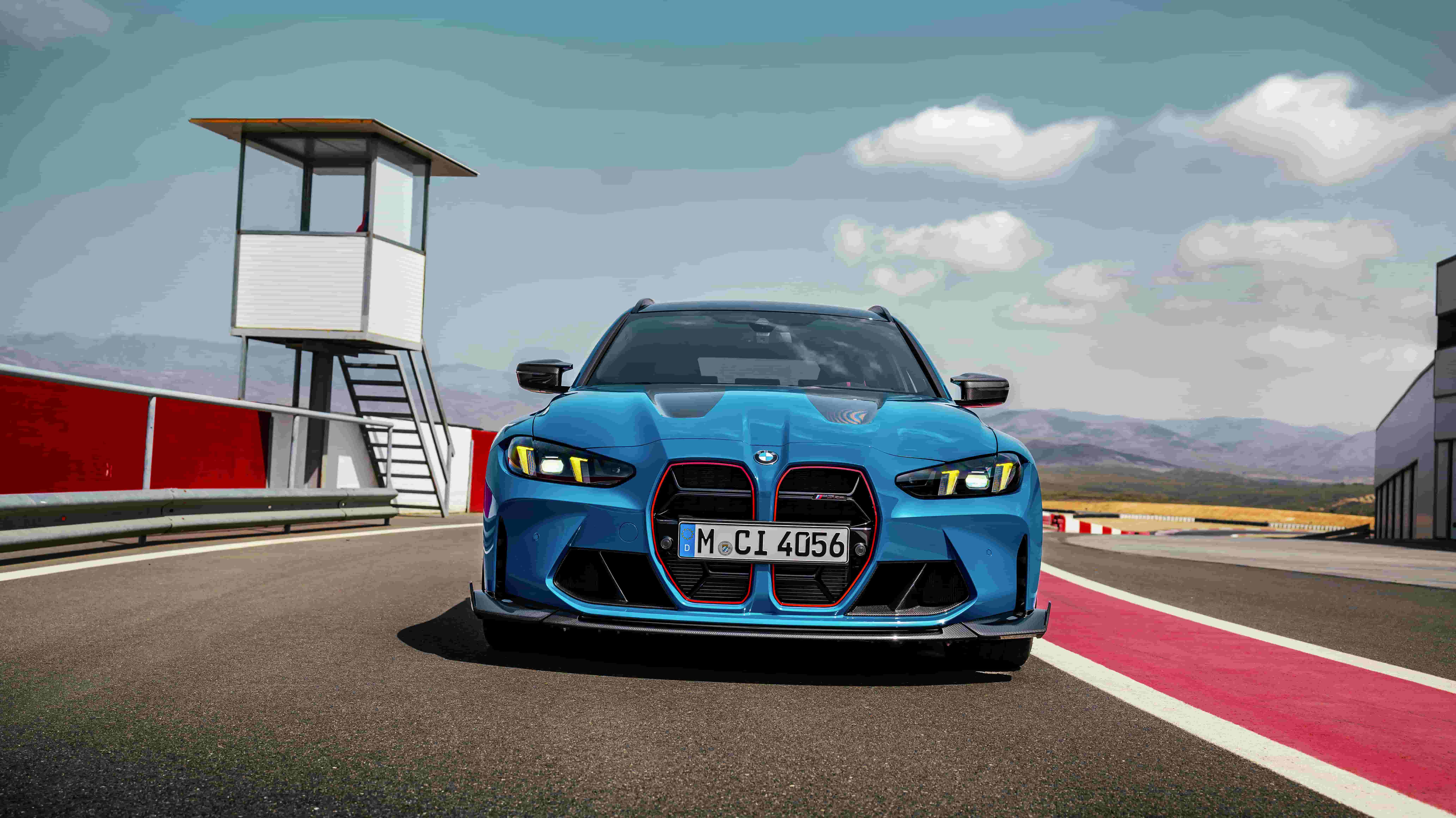 BMW M performance car driving on a racetrack under clear sky