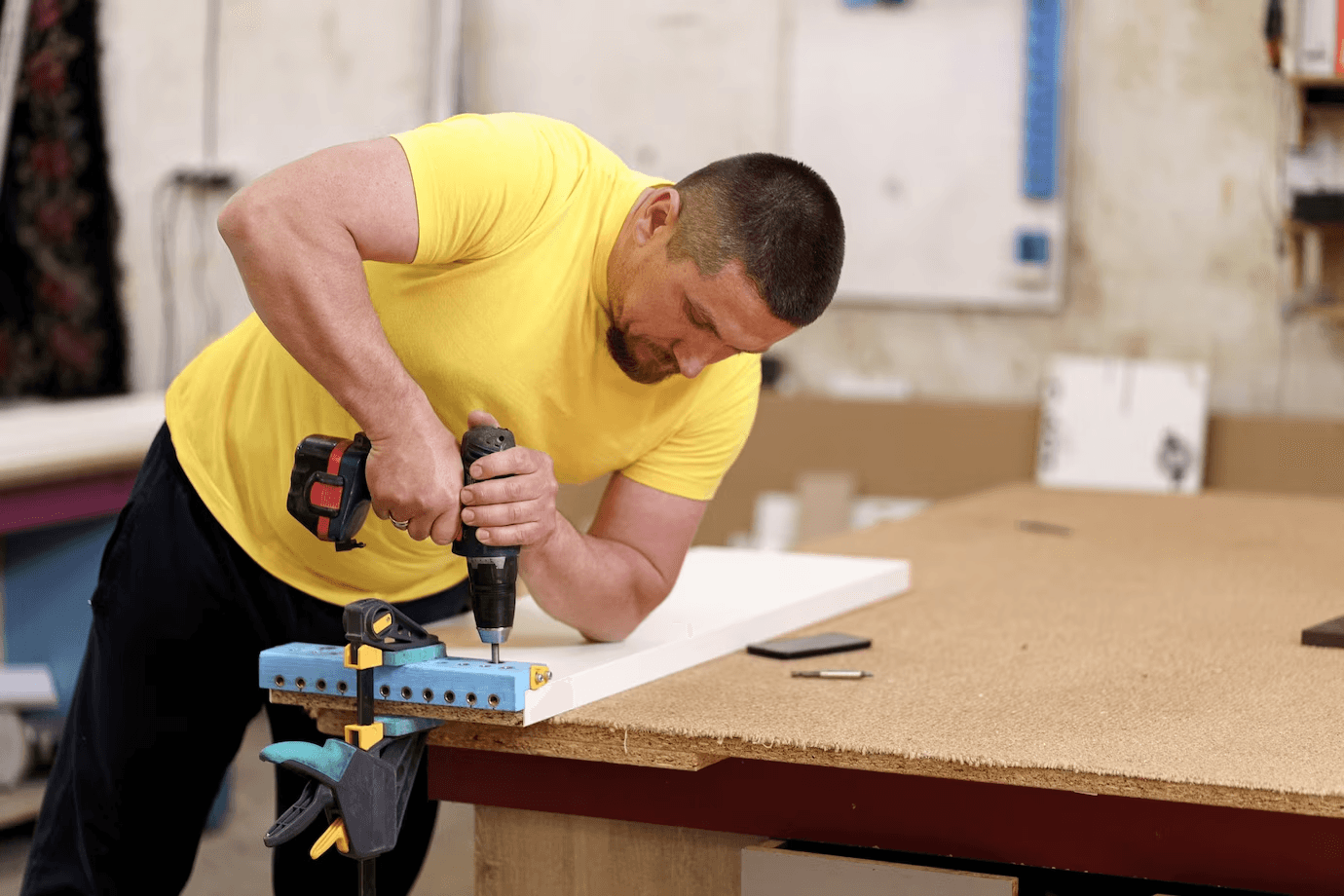 Tradesperson drilling a white board in the Rivet workshop