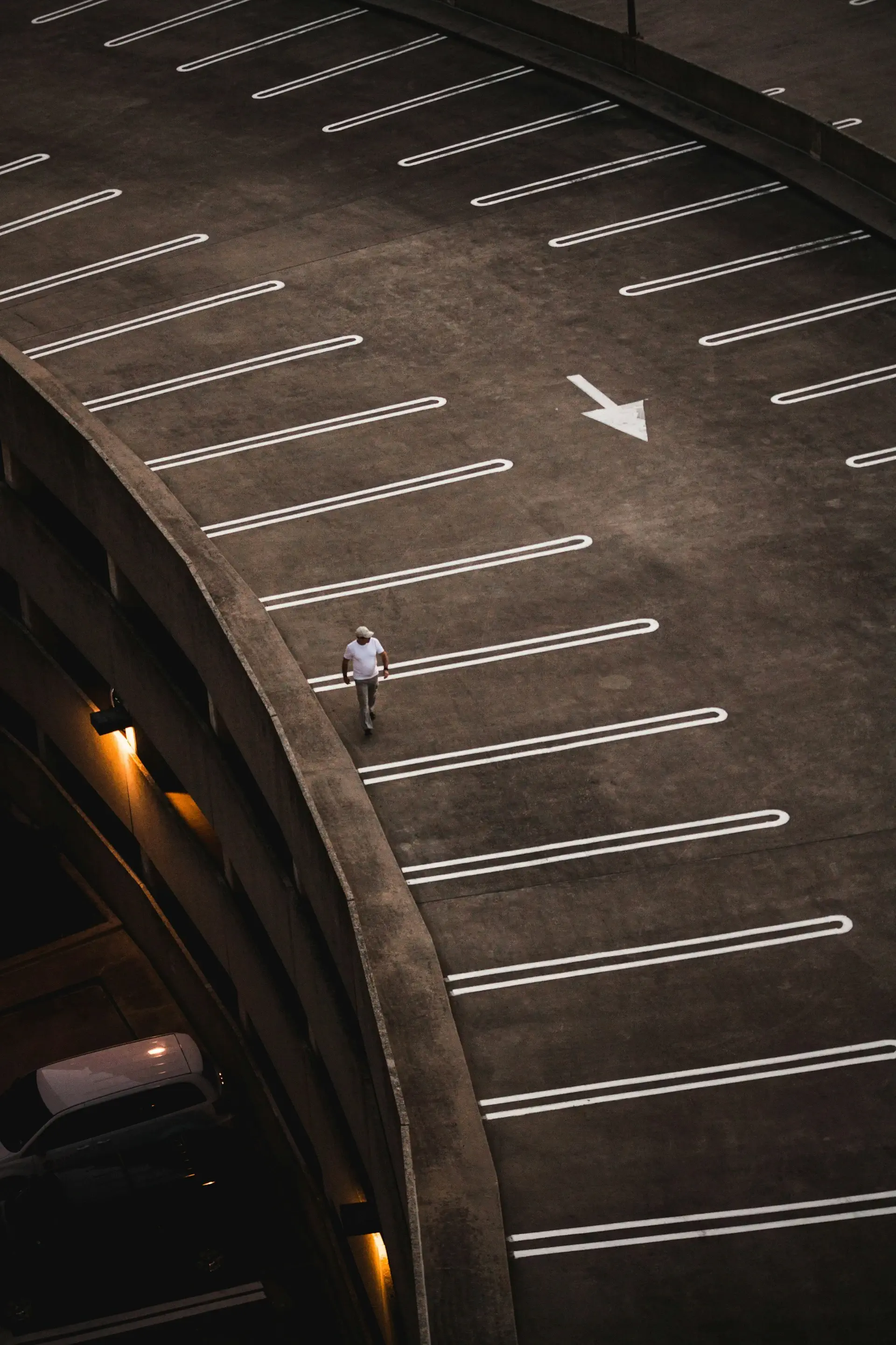 Man walking across striped parking lot to check project