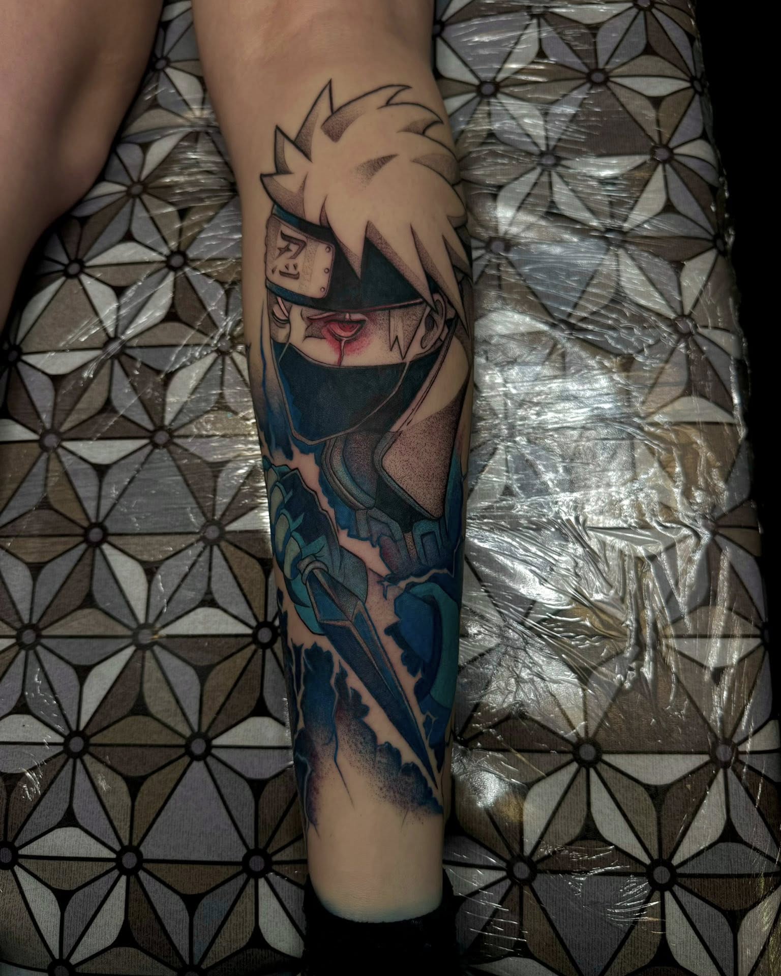 A forearm tattoo of Nezuko Kamado from Demon Slayer, depicted in a stylized anime art style. She is holding a sword.