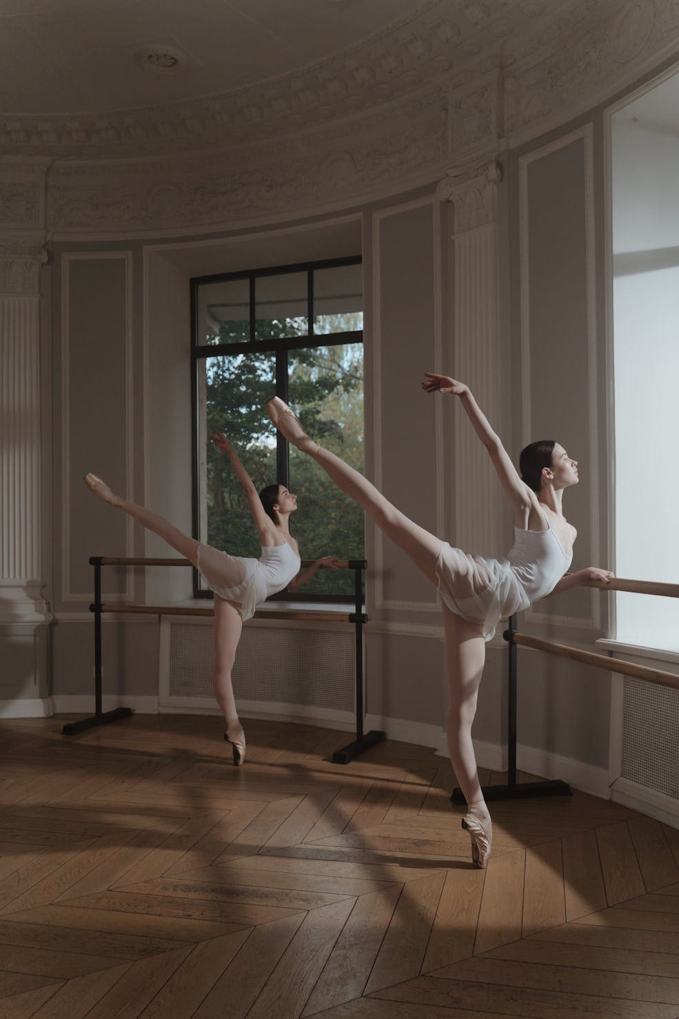 Two ballet dancers practising in a white room