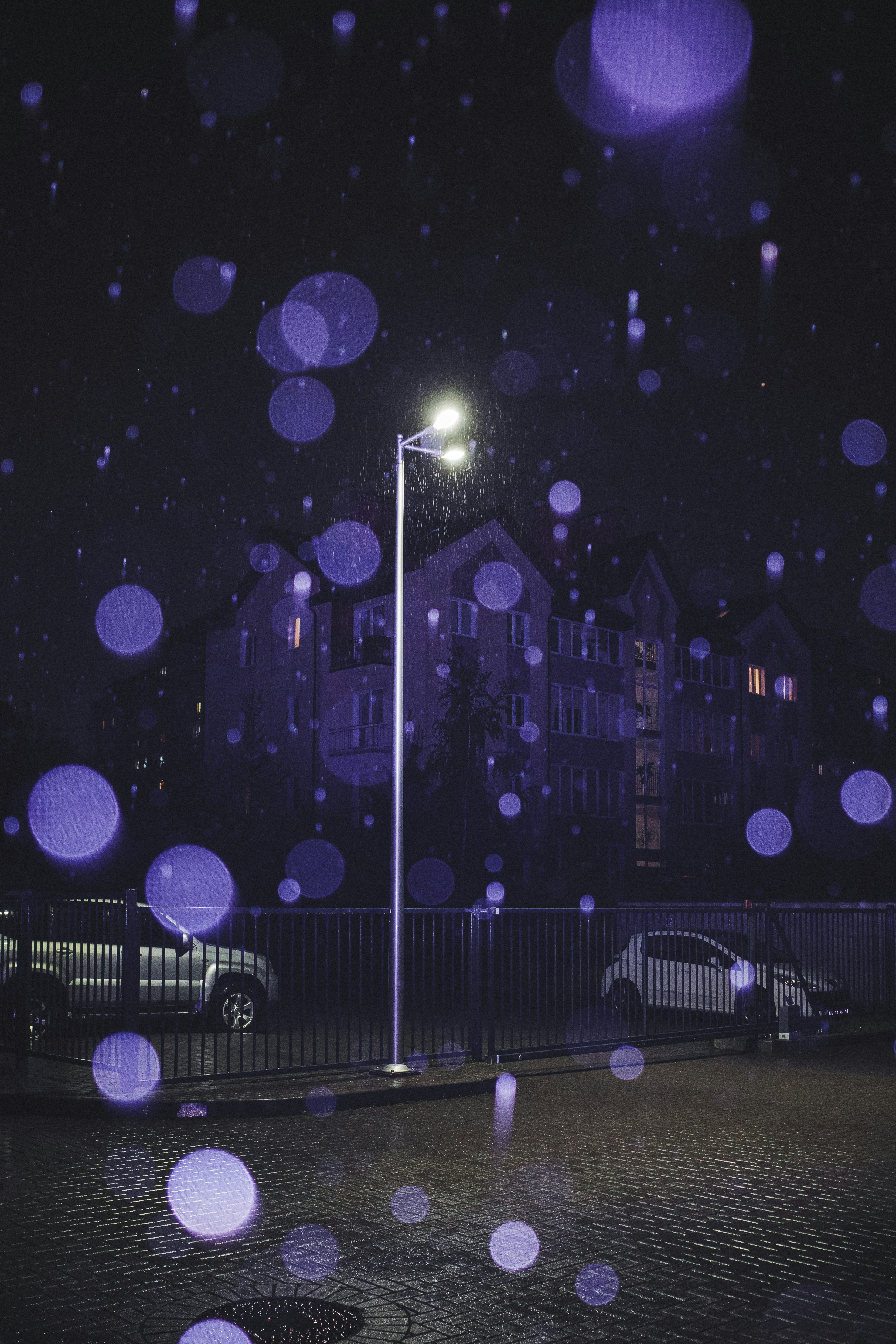 Streetlight illuminates a rainy night with bokeh lights