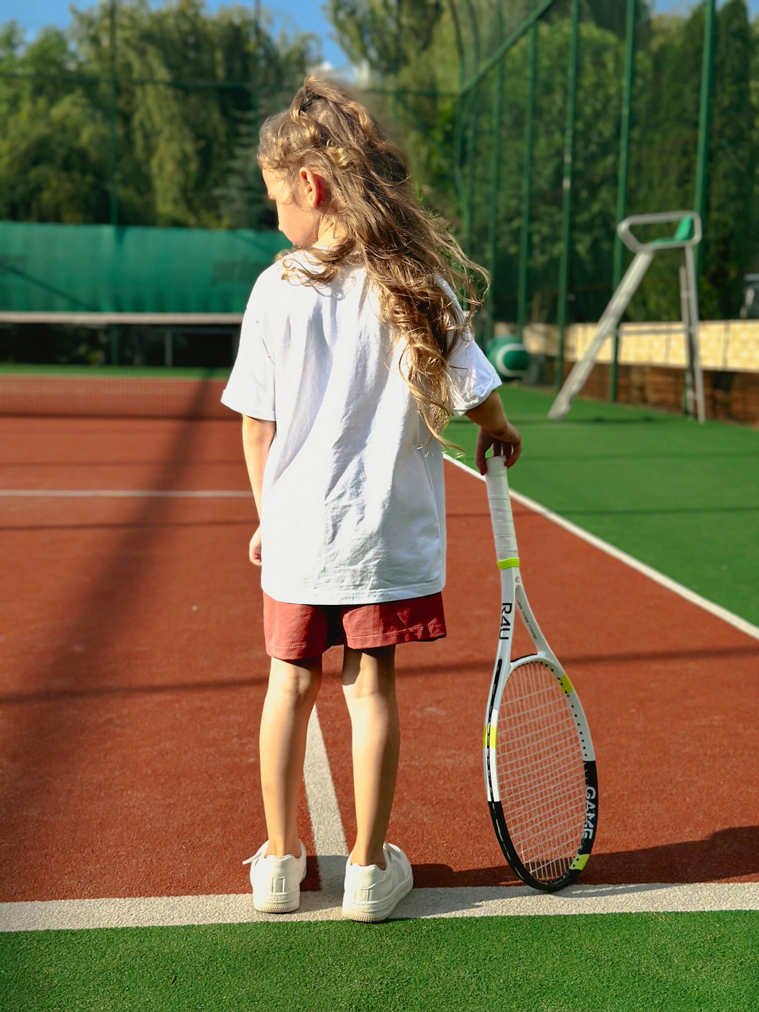 Mädchen mit Tennisschläger auf dem Kleinfeld