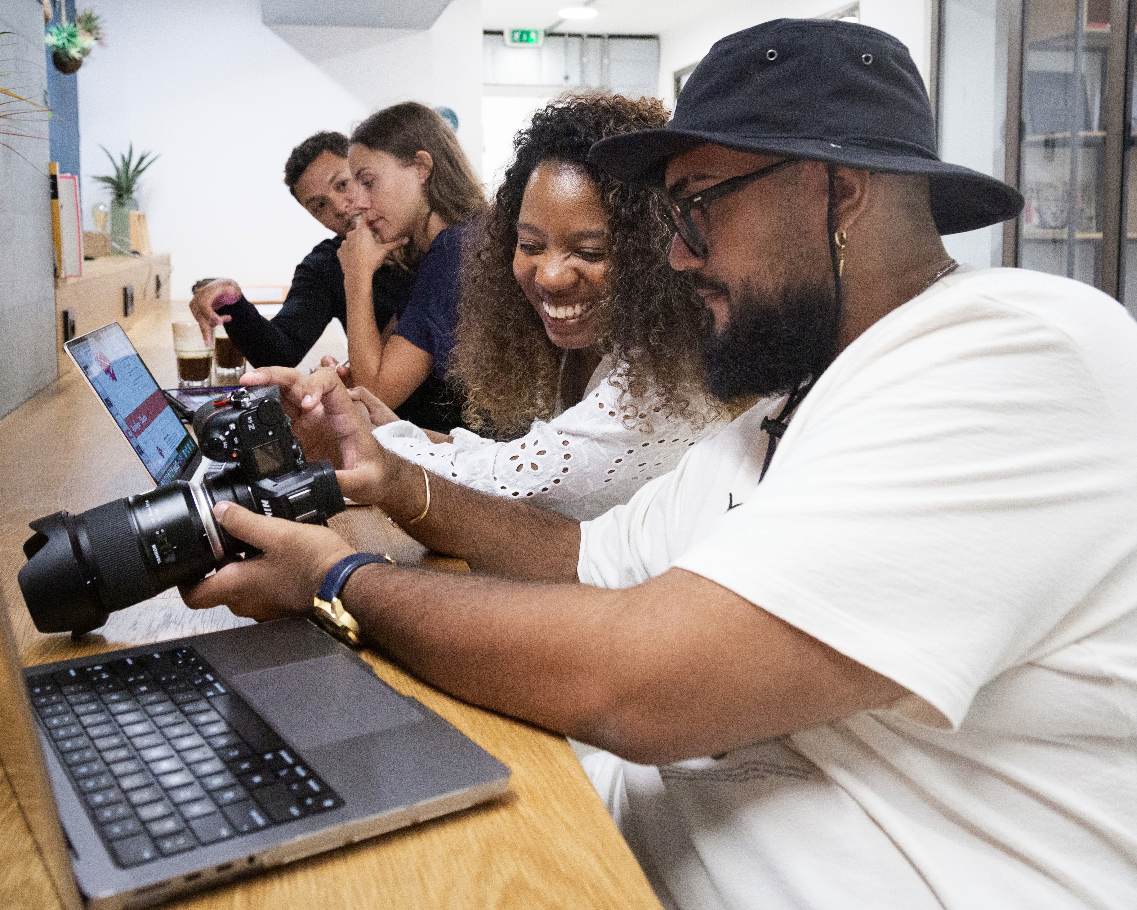 Three people sitting on a couch in a room looking at mobile devices