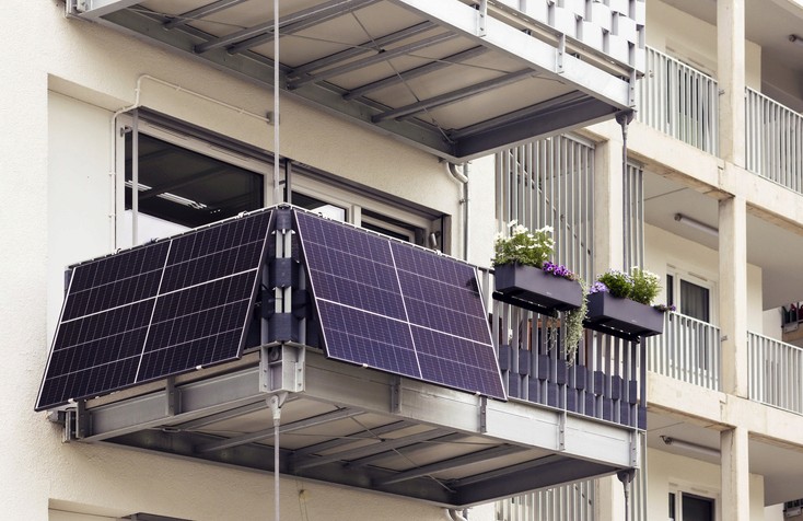Zwei Balkone mit darauf montierten Solarpaneelen, die an einem modernen Gebäude angebracht sind.