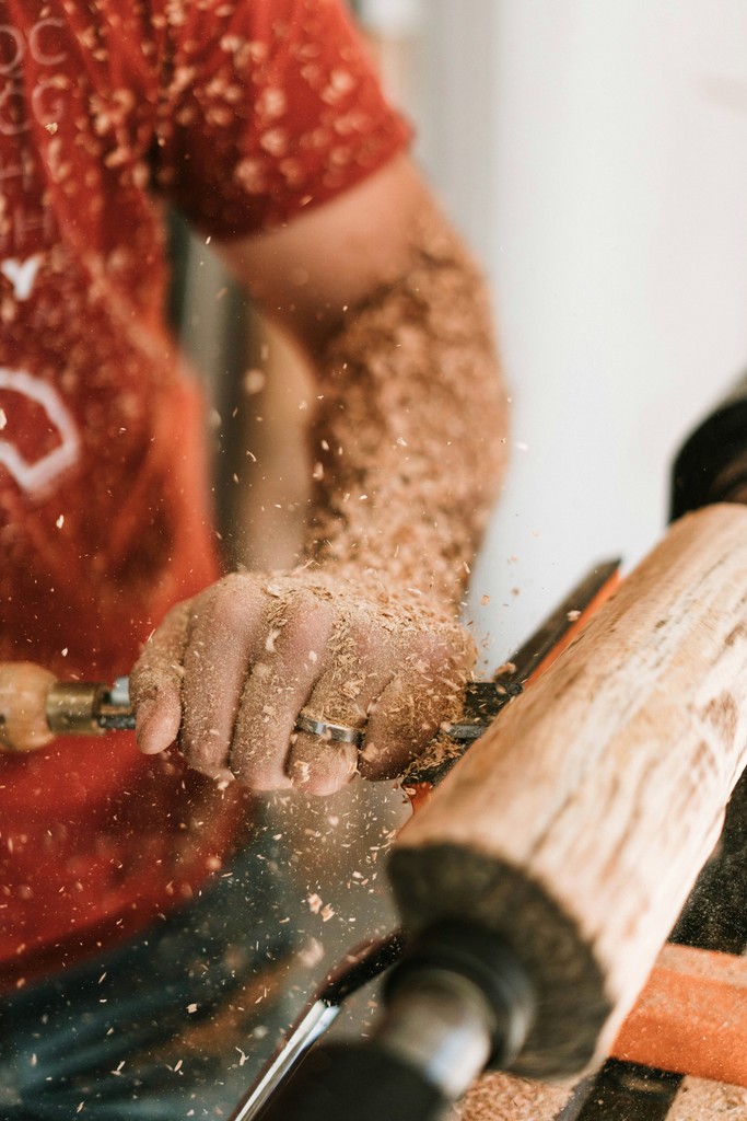 A woodworker using their tools on a log