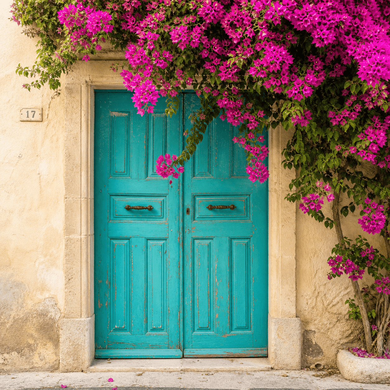 Charming rustic entrance of a coastal home near Barcelona with a bright blue door and bougainvillea, representing premium real estate and living in Maresme.