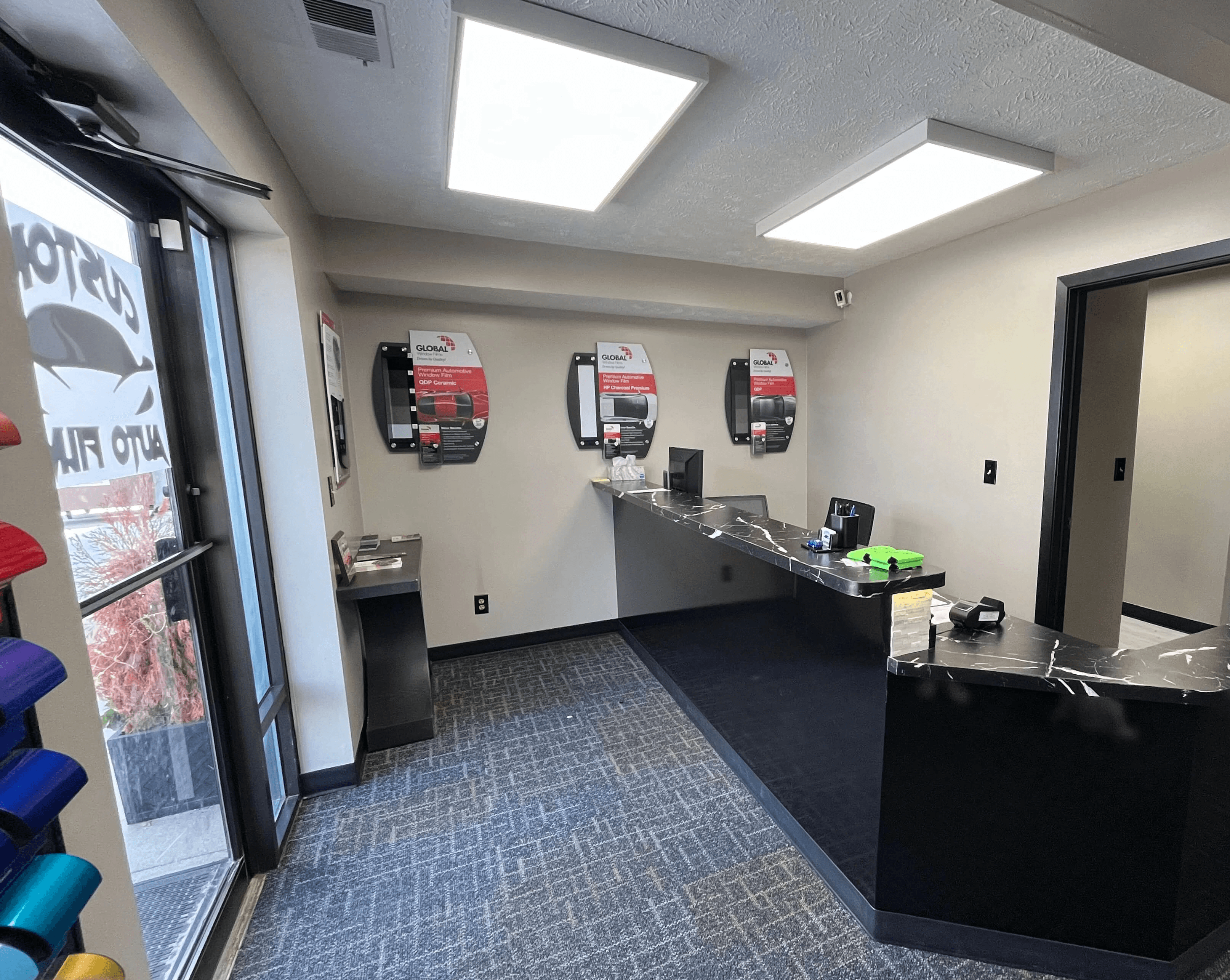 A modern office reception area featuring a black marble-patterned front desk with a sleek angular design.