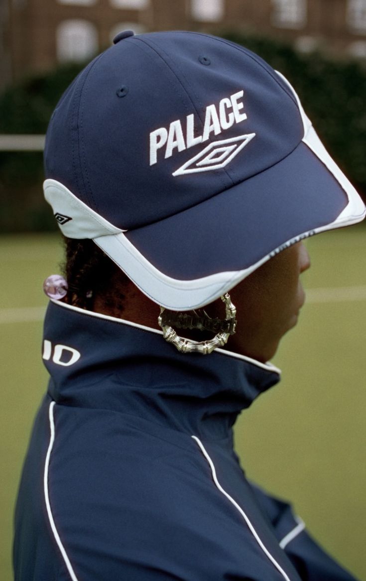 a woman wearing a dark blue hat with the palace logo