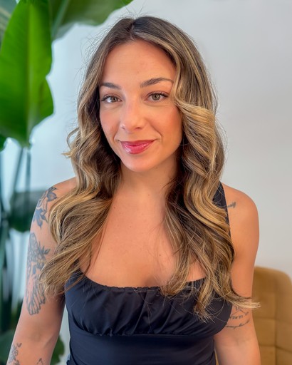 A wooden essential oil diffuser releasing a gentle stream of steam, surrounded by dried herbs and a small bottle of essential oil. The warm lighting enhances the cozy and therapeutic ambiance.