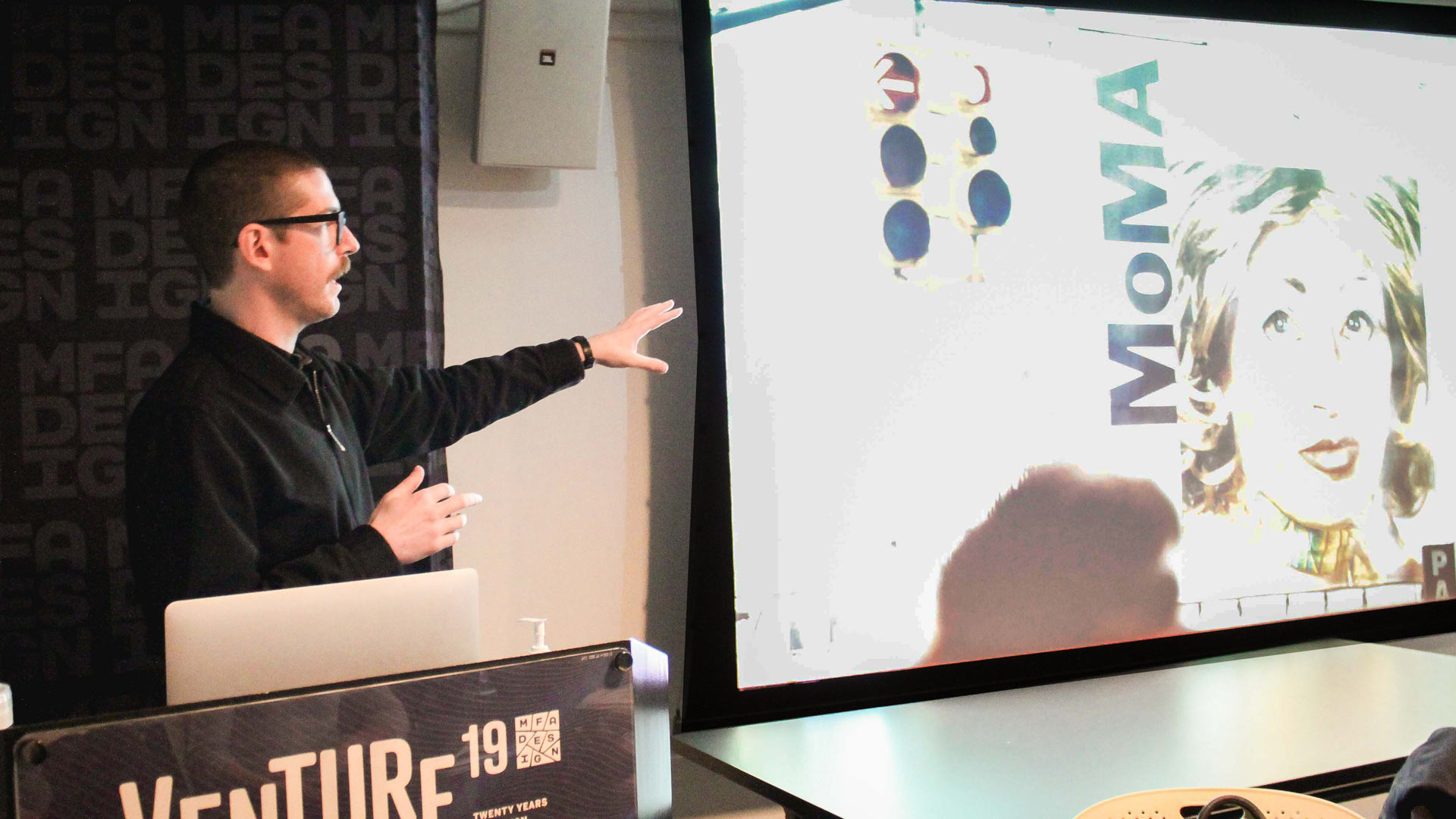 Jesse Reed at SVA MFA Design giving a lecture in a darkened classroom