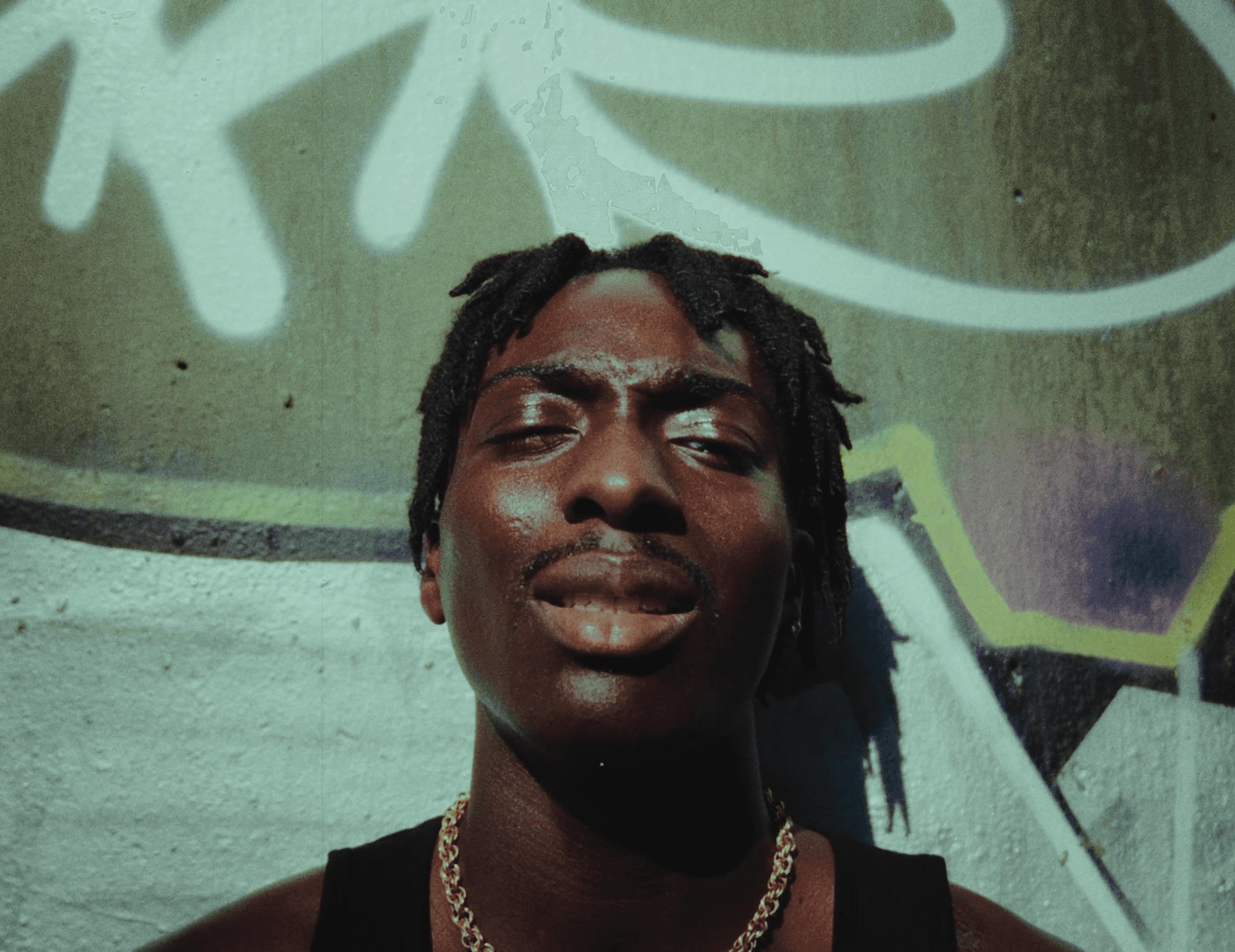 A person walks down a dimly lit alley at night.