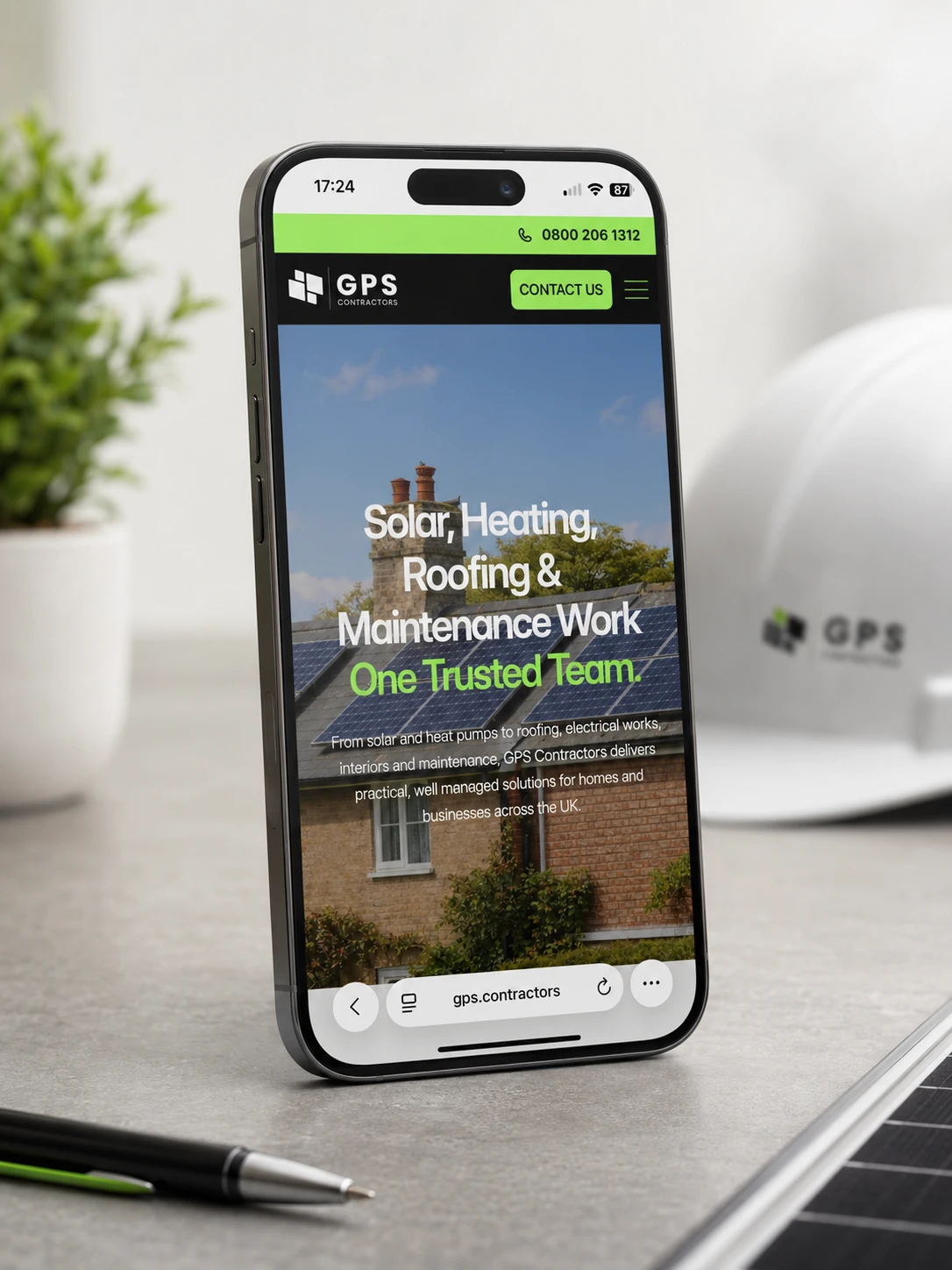 Phone displaying GPS Contractors website with solar panels.