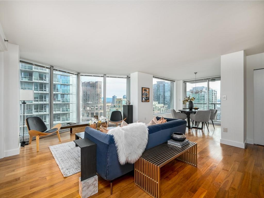 A modern, open-plan office space with large windows, wooden floors, and minimalist furniture.