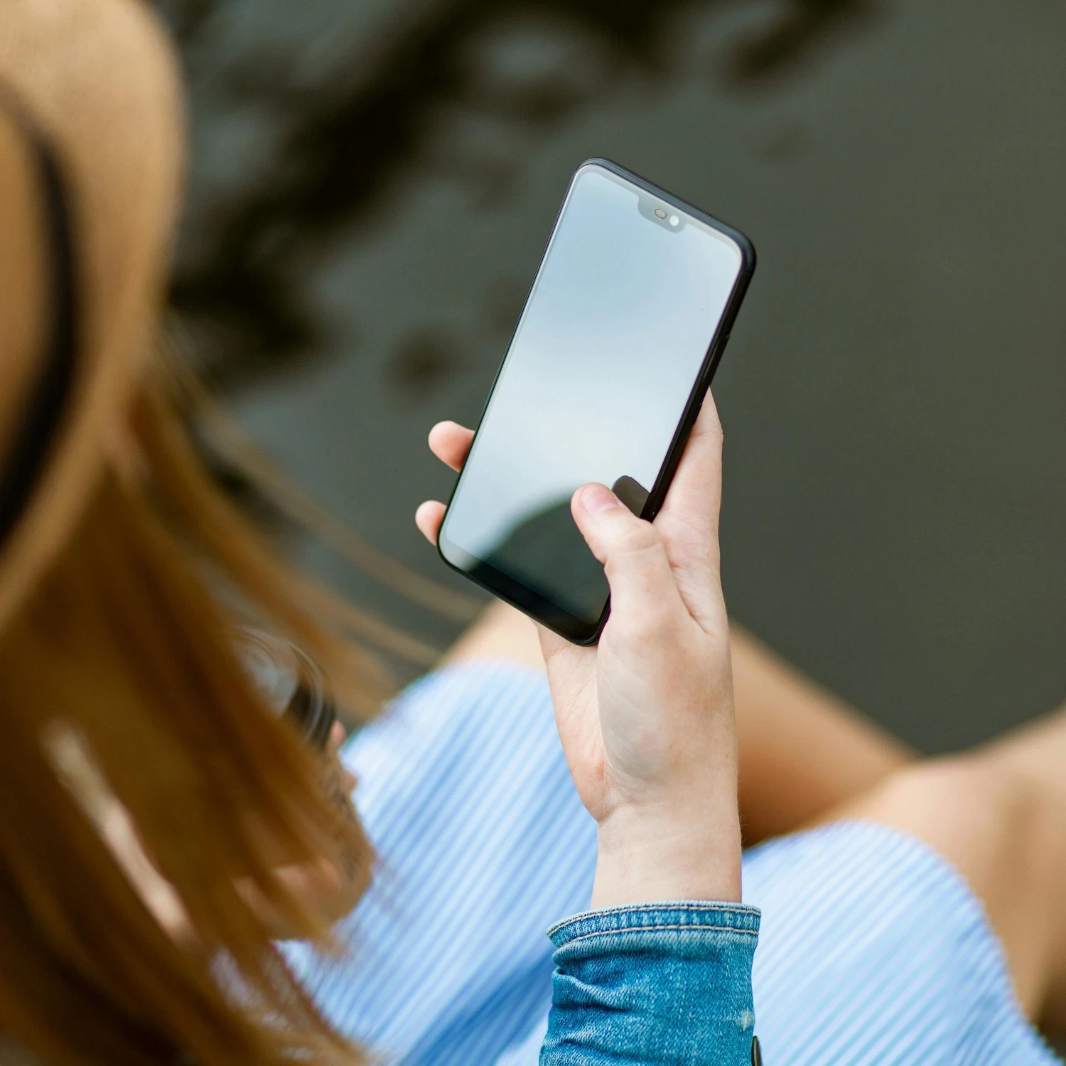 Person holding smartphone outdoors, exploring options for group therapy sessions and online support in NYC.