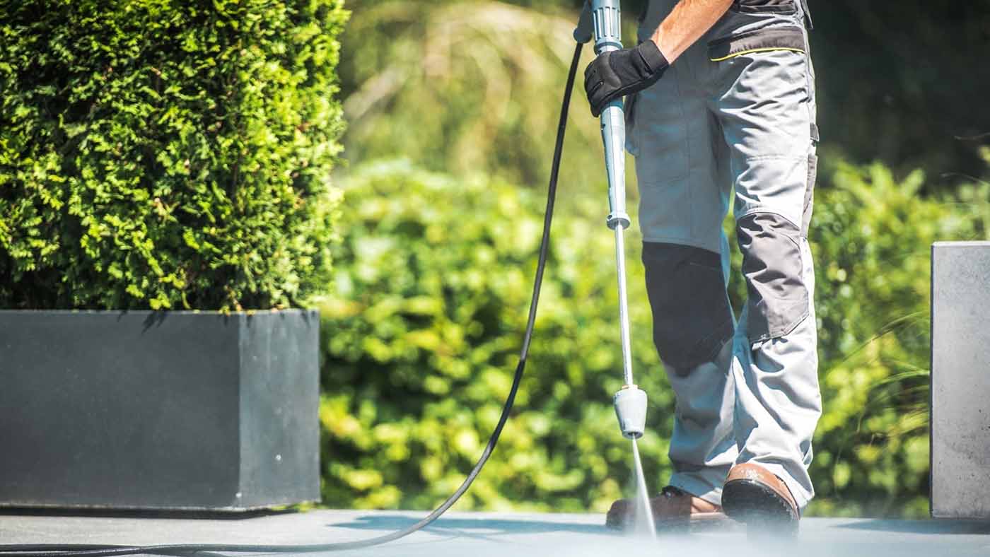 AQWA technician using high-pressure cleaning equipment on industrial surfaces