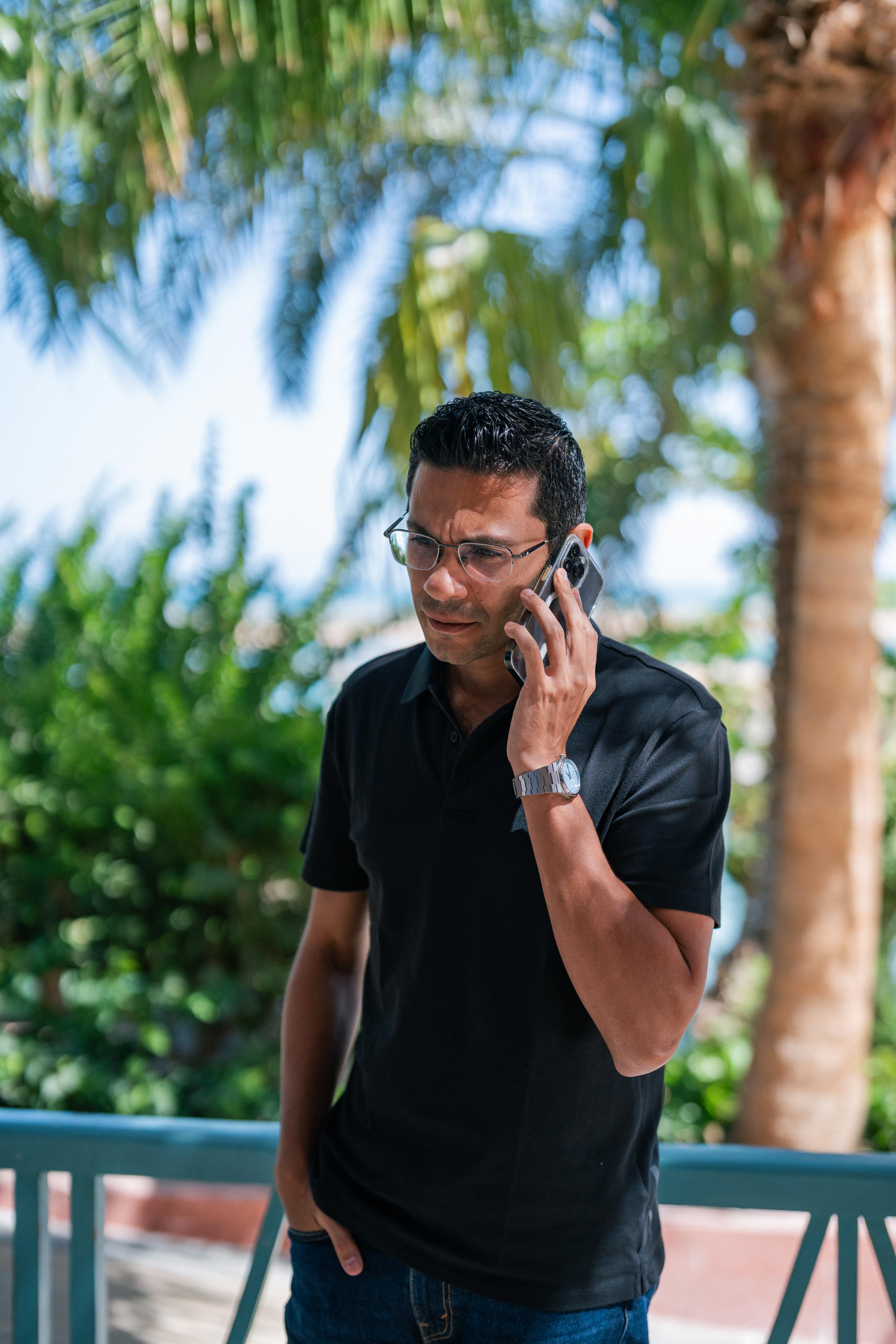 An image of khaled radwan holdign his phone like he is talking to someone