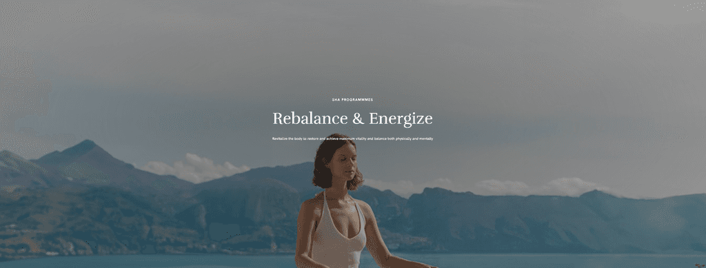 "SHA 웰니스 웹사이트 캡처 이미지, 고요한 호수와 산을 배경으로 명상 중인 여성, 'Rebalance & Energize' 프로그램을 강조하는 텍스트"