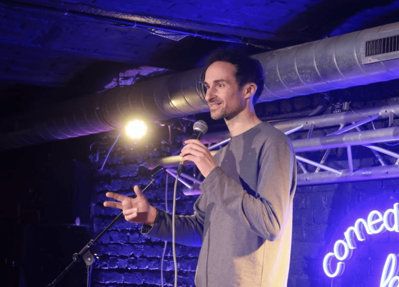 Alban et sur scene avec un micro il fait du stand up