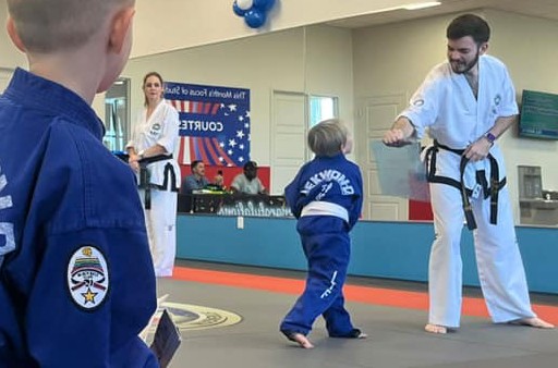 Young student practicing a punch with an instructor.