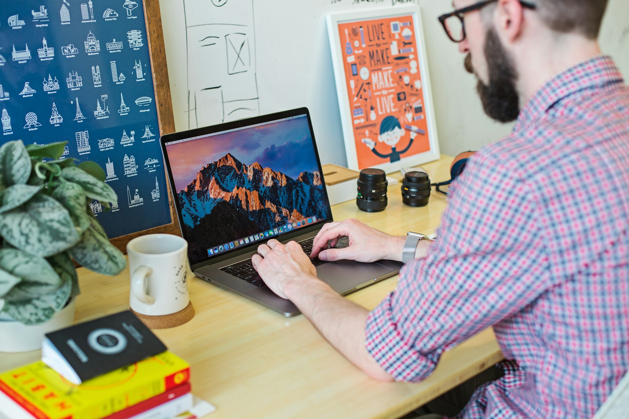 A man sat at his desk who is about to start making a resume on his MacBook